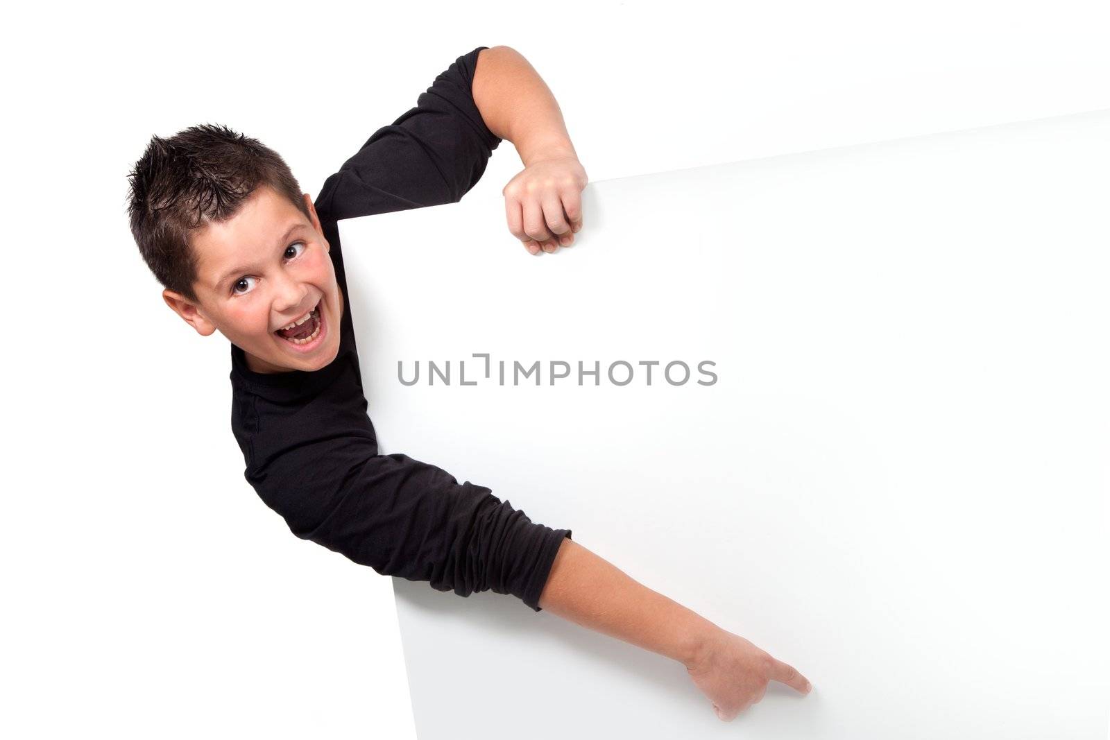 Smiling teen boy pointing finger on blank board with copyspace