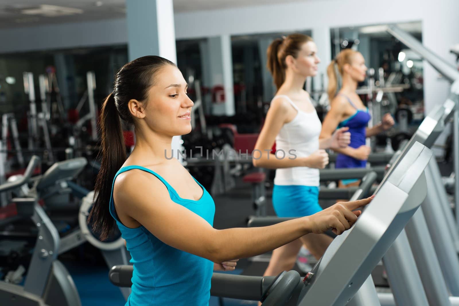 young women running on a treadmill by adam121