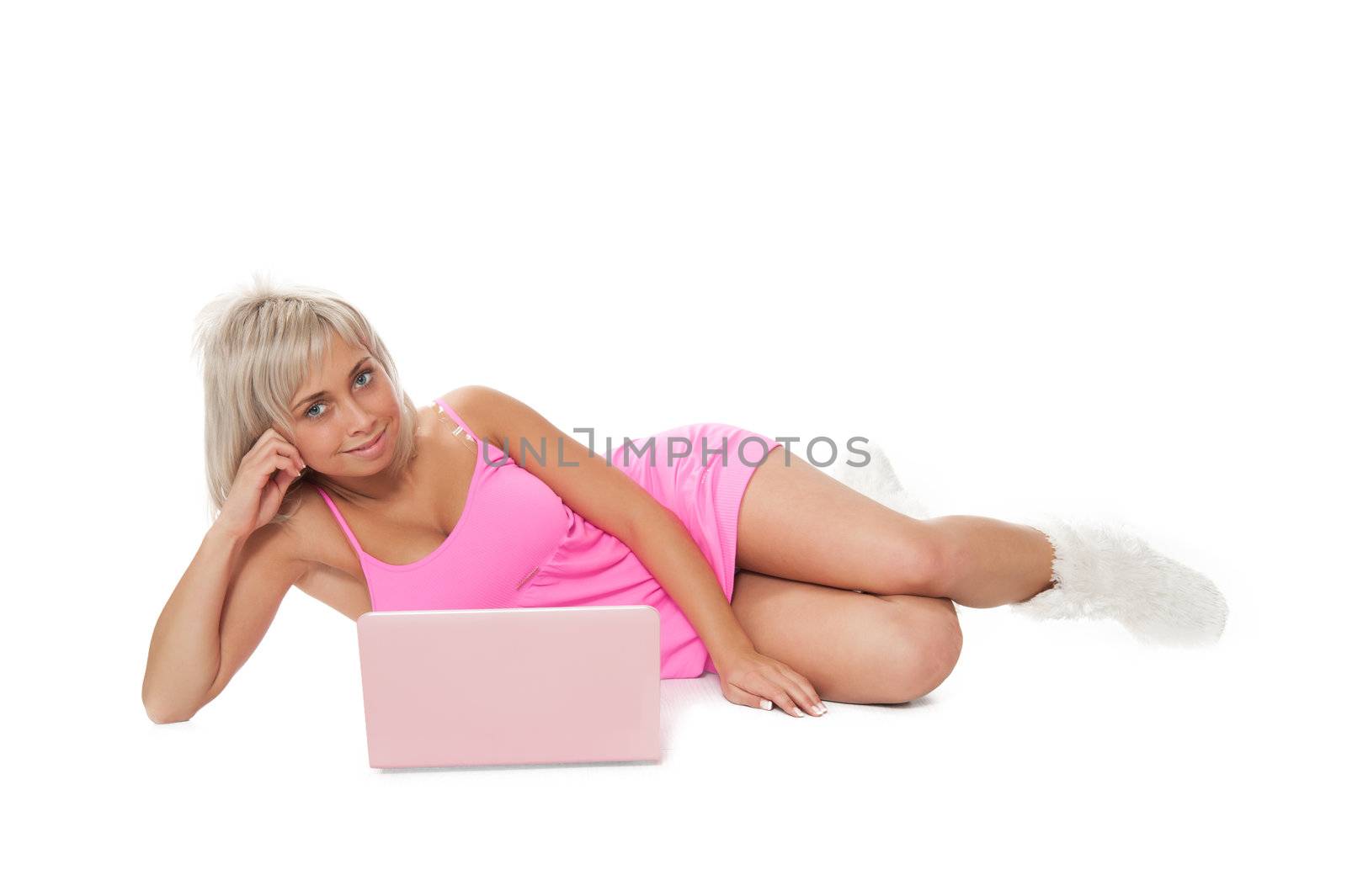 Beautiful blonde in a pink dress is in a laptop
