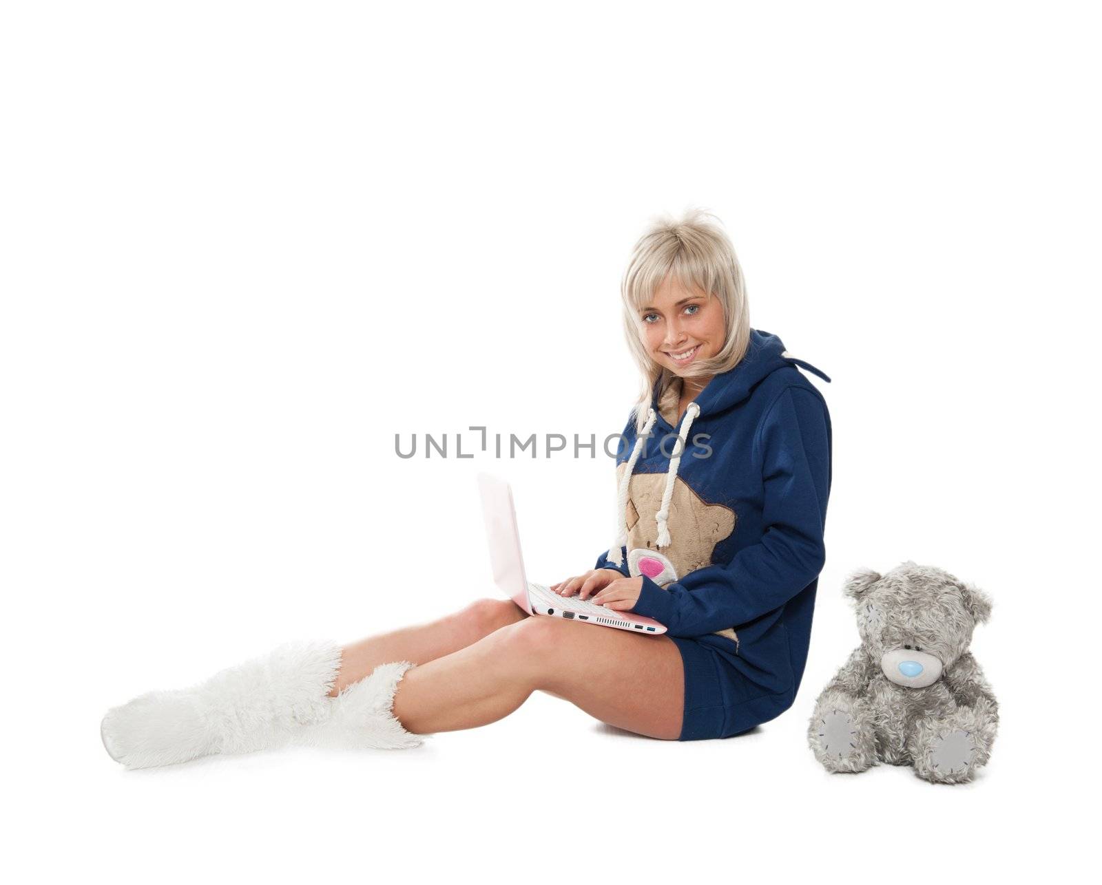 lgirl with a teddy bear on the floor with a laptop