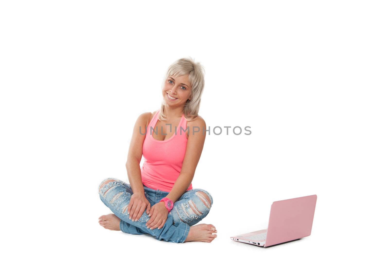 girl in a pink shirt, blue jeans sitting with a laptop