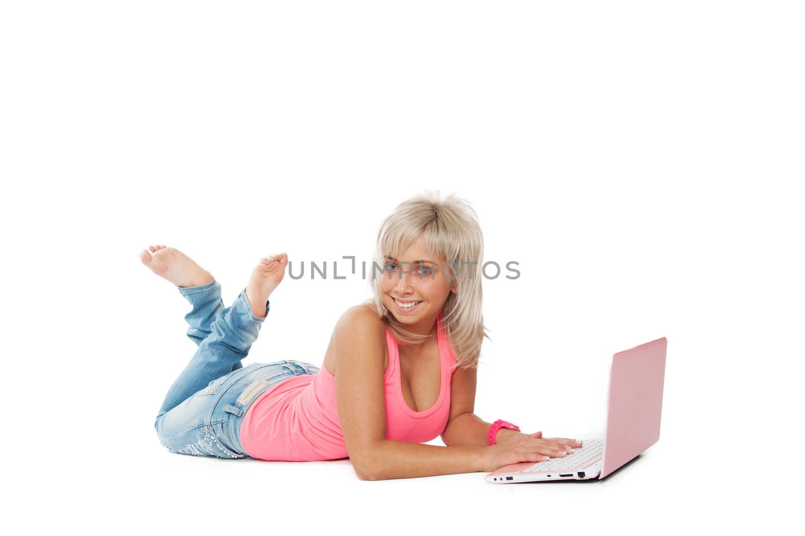 girl in a pink shirt, blue jeans lying with a laptop