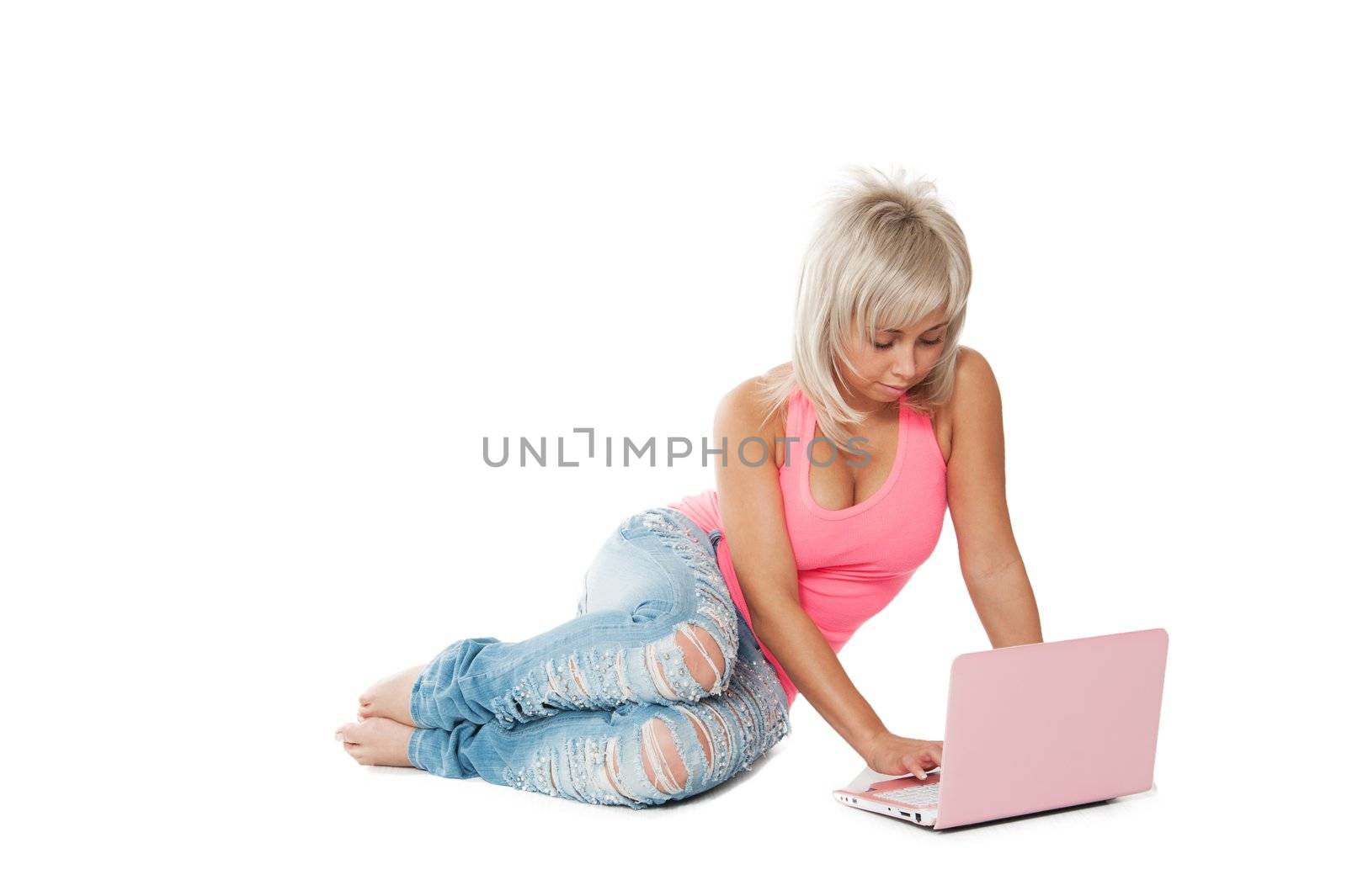 girl in a pink shirt, blue jeans sitting with a laptop