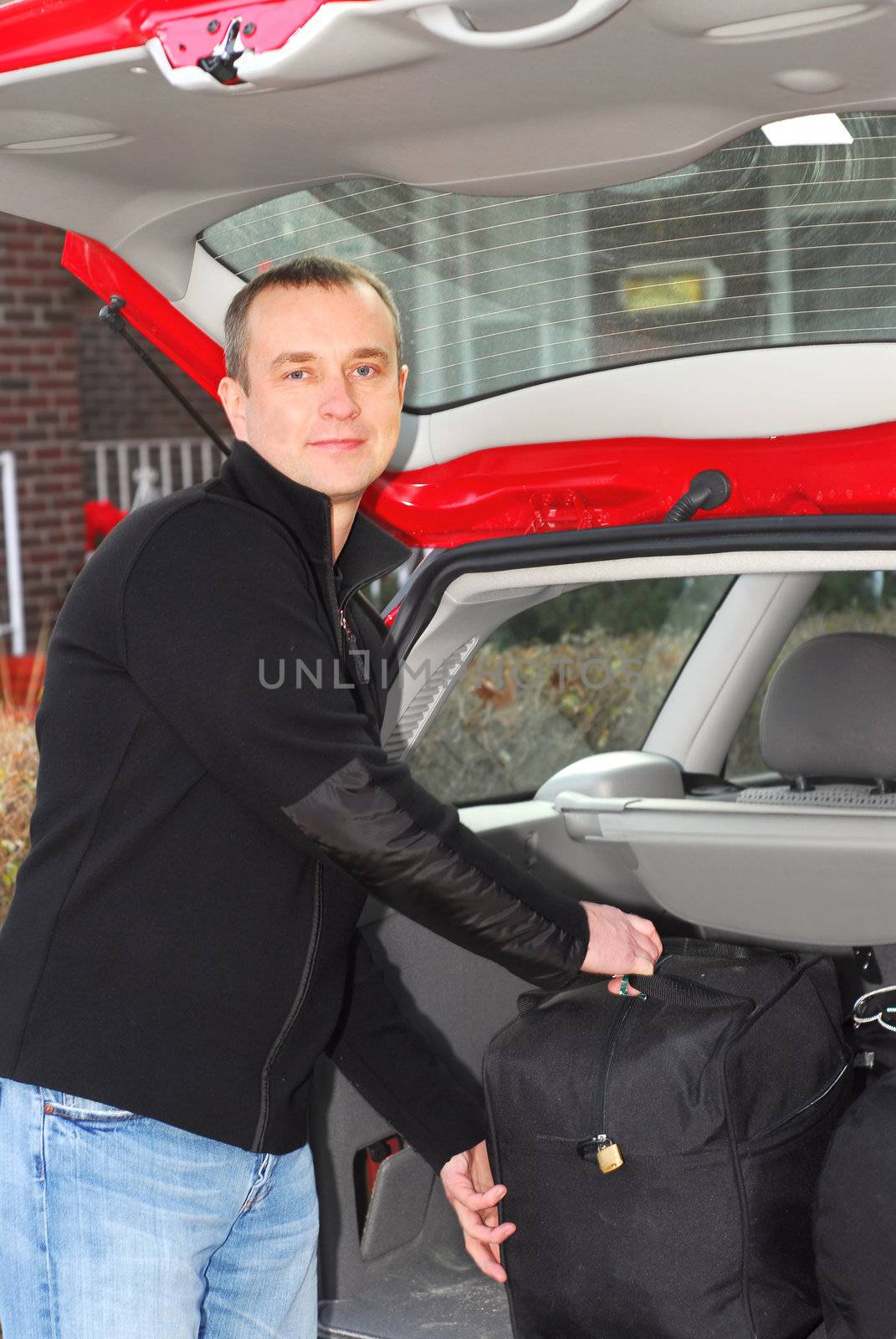 Man loading bags in the trunk of his car