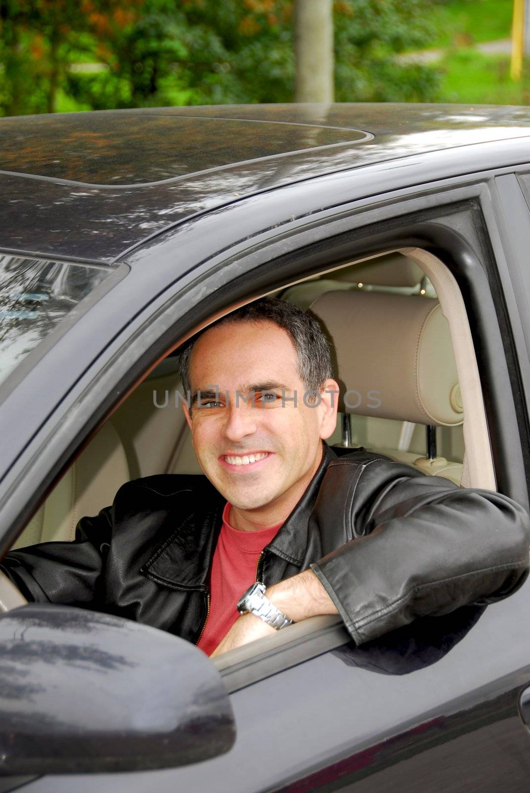 Smiling happy man looking from a car window