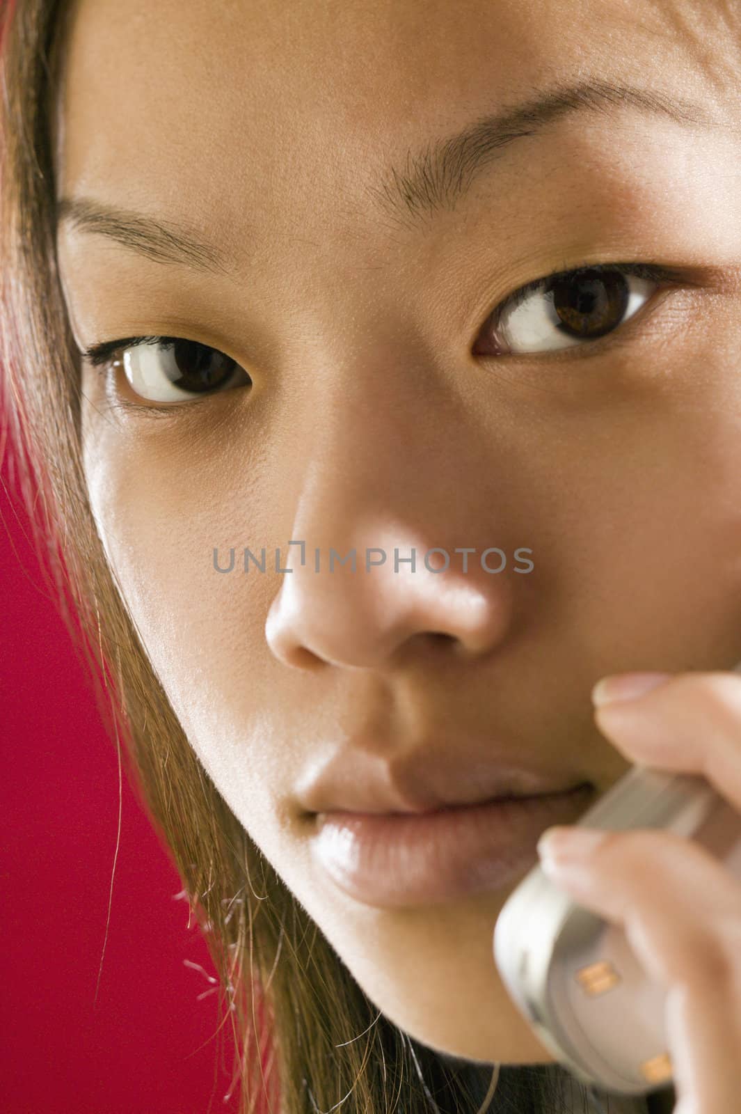 Close up view of a young Asian girl using a cell phone