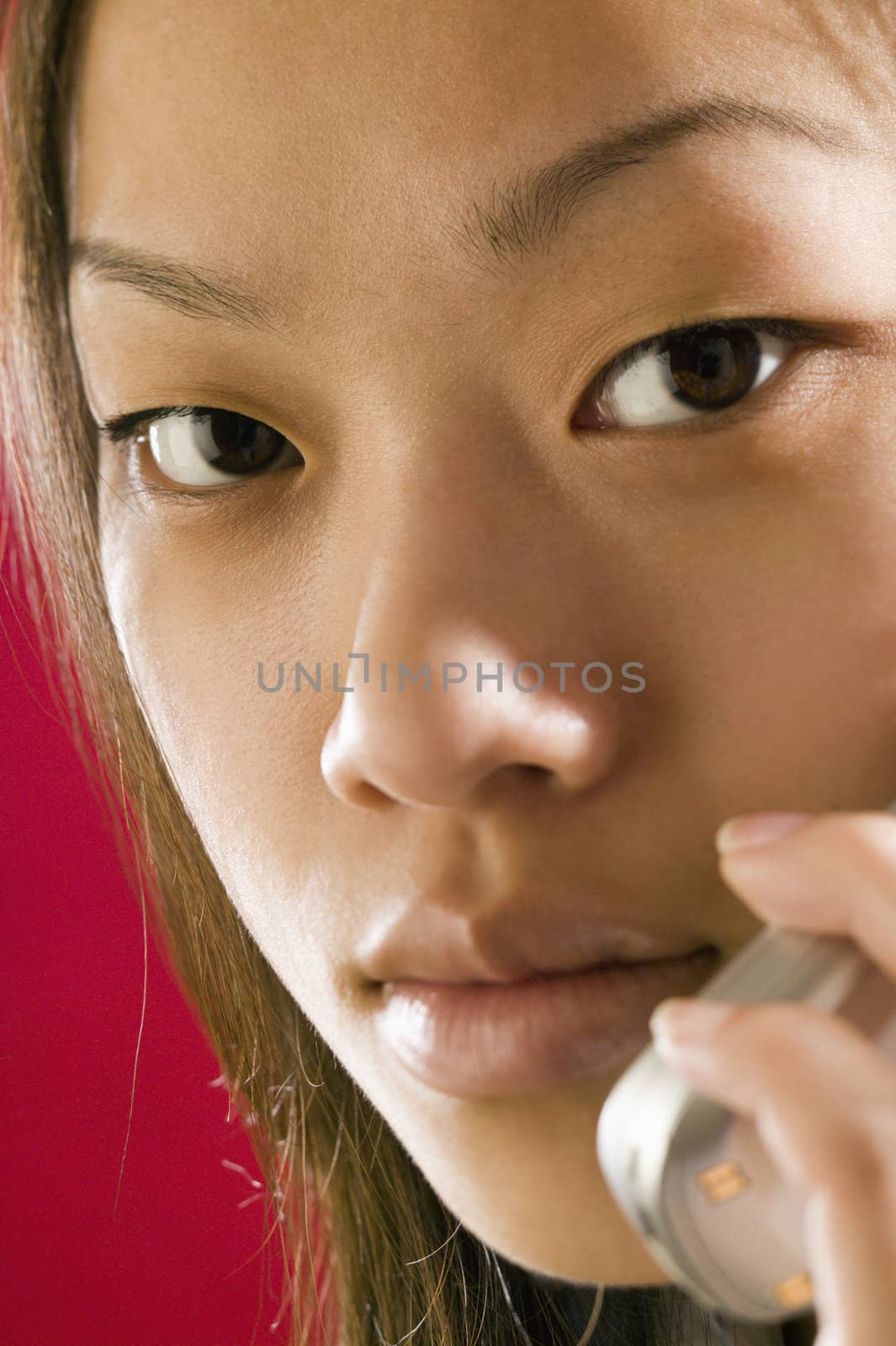 Close up view of a young Asian girl using a cell phone