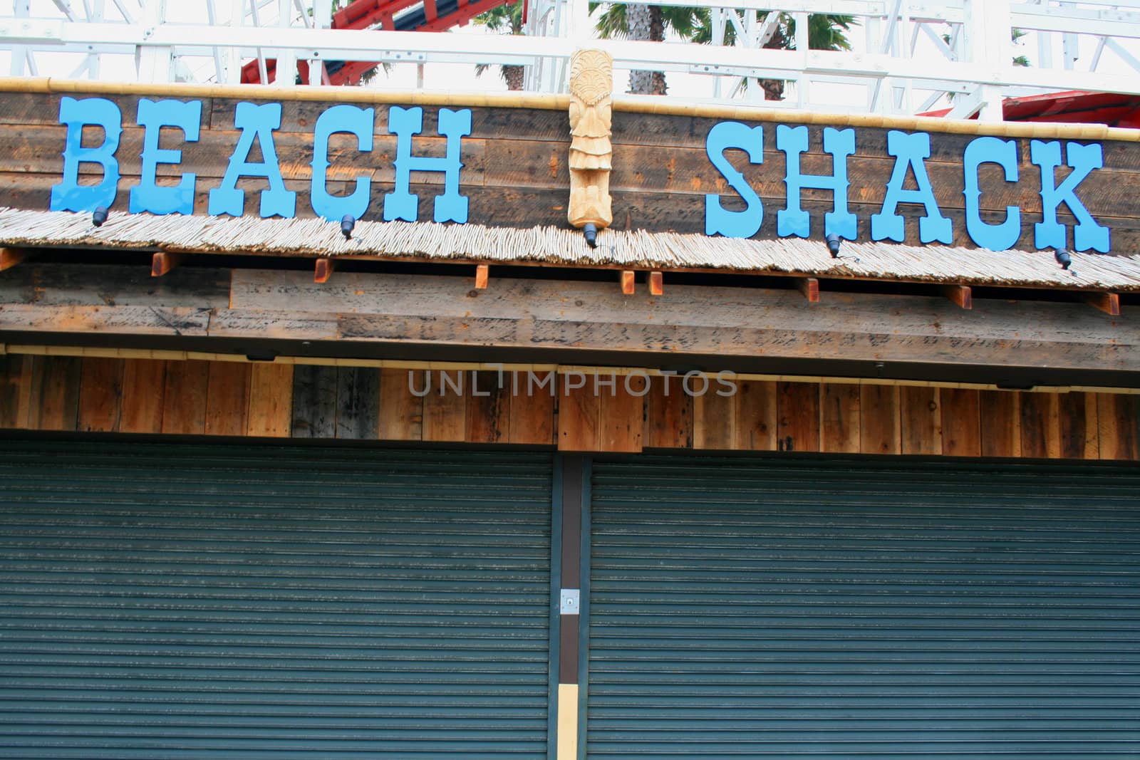 Close up of a beach shack sign and a totem pole.

