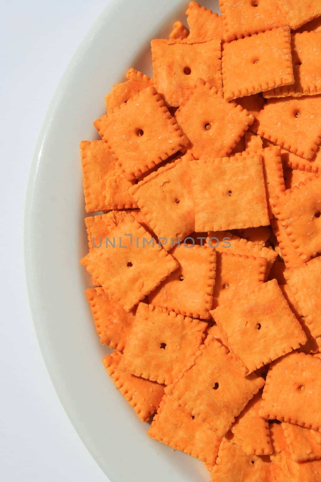 Close up of orange cheese crackers on a plate.
