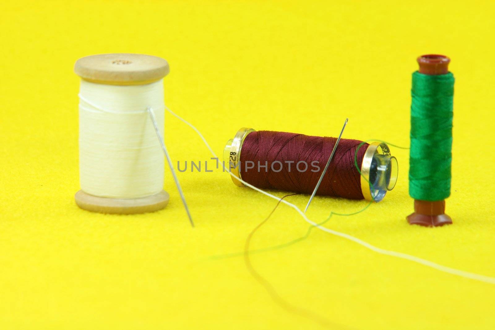 string rolls and needles in yellow background sewing handcrafted concepts