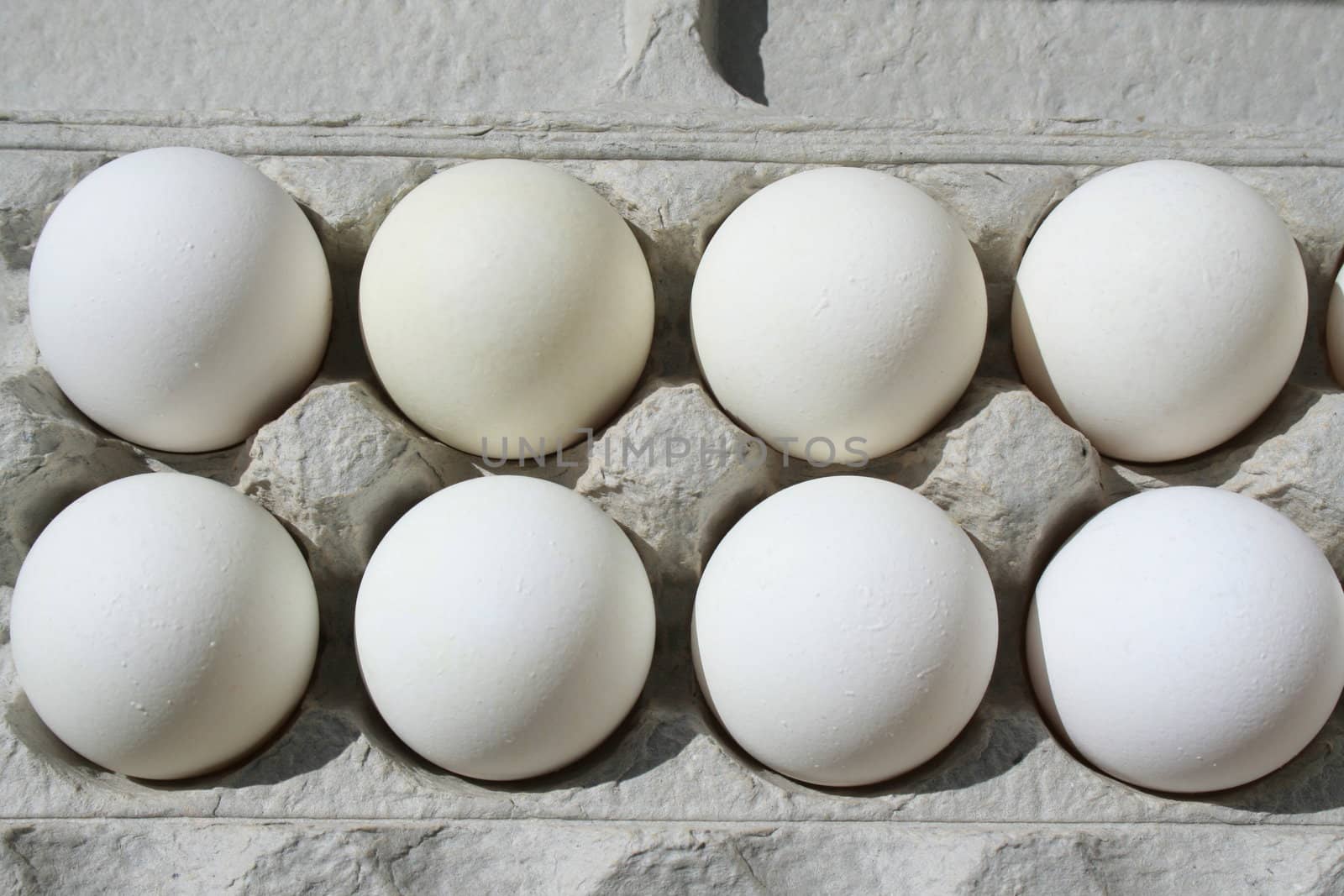 Close up of chicken eggs in a carton.
