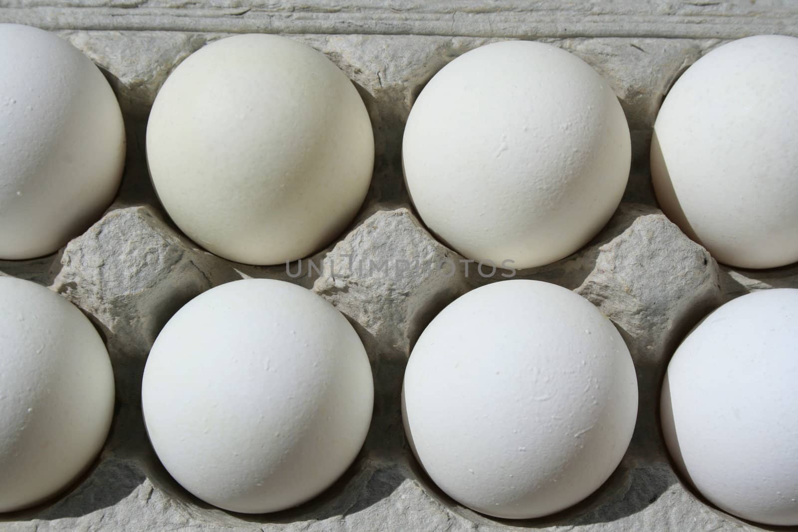 Close up of chicken eggs in a carton.

