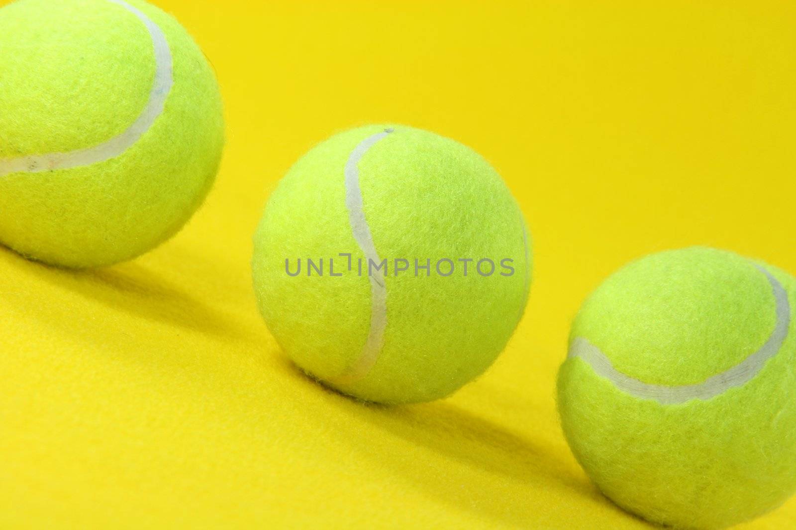 closeup three yellow tennis balls in yellow background sports concepts