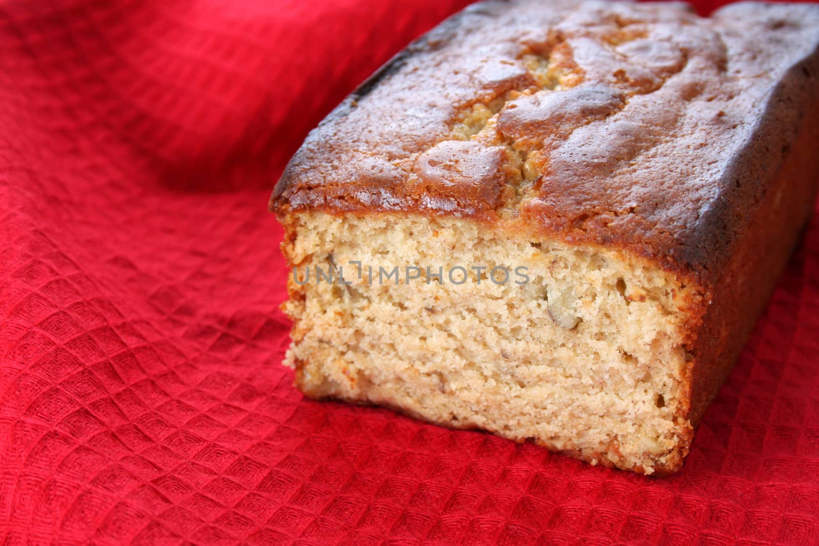 Loaf of banana nut bread on a red towel