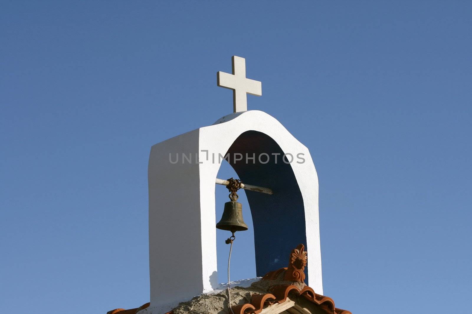 detail from small orthodox church the bell and the cross with total blue sky background athens greece