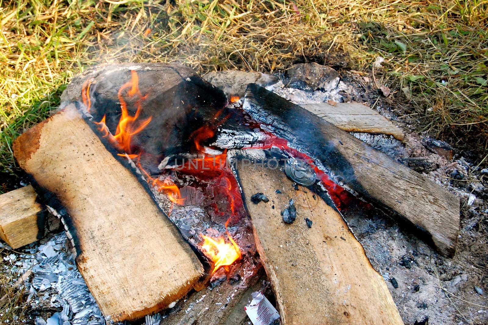 Campfire burns in the grass