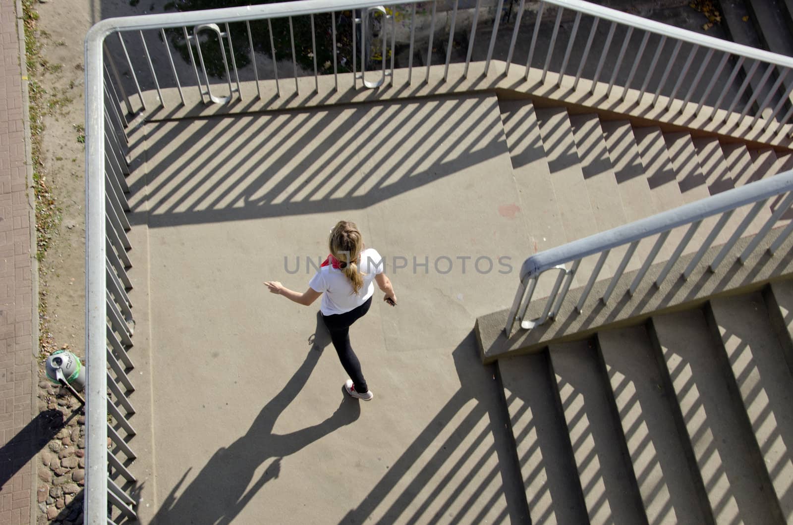 Girl setting downstairs railings sunlight shadows by sauletas