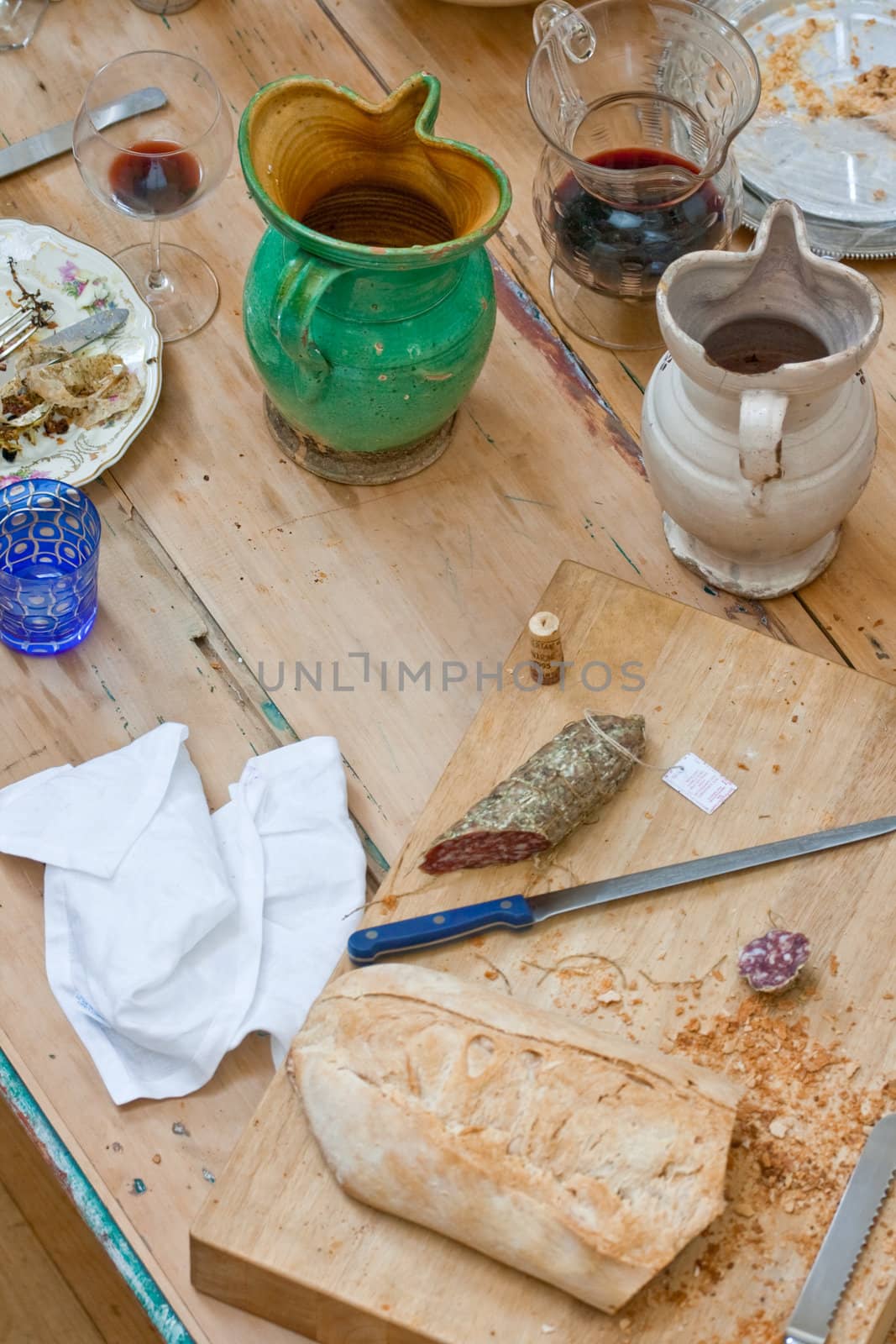 Bread, salame and wine inside a ceramic pitchers