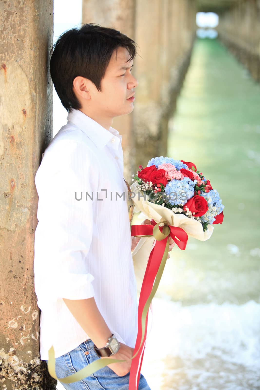 portrait of man with beautiful bouquet on the beach