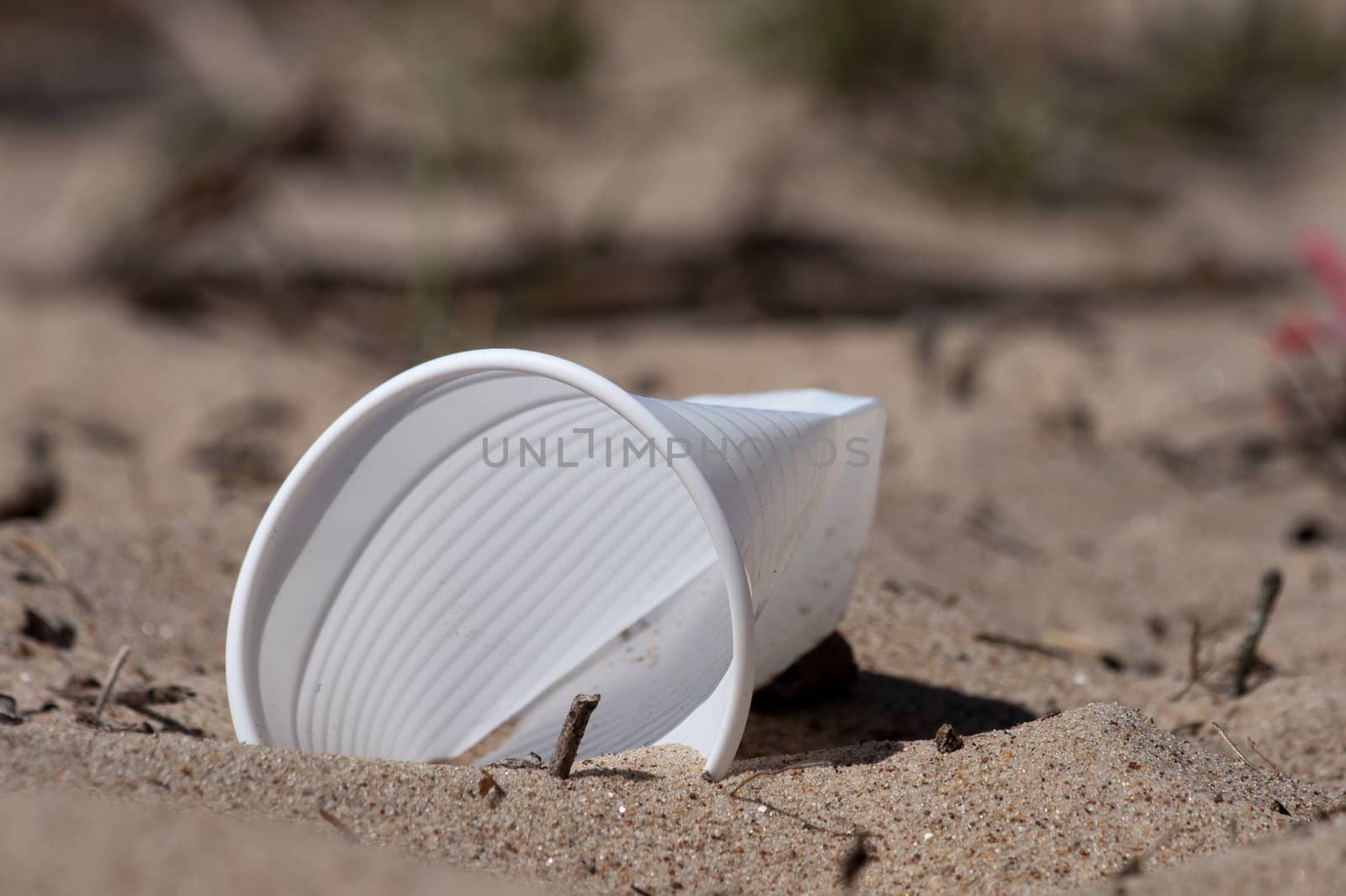 a plastic glass in a beach sand