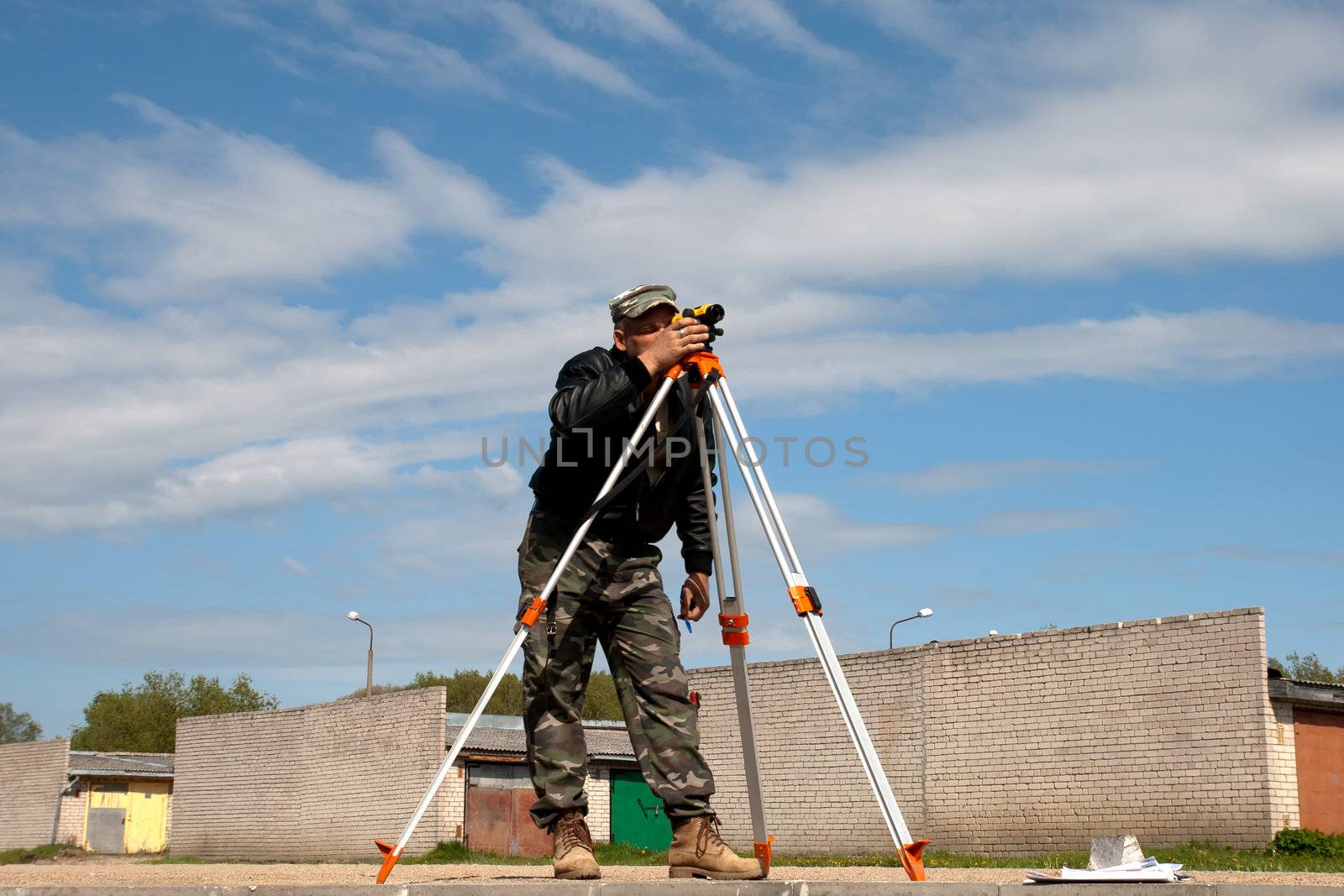 Surveyor measuring land for new street build.