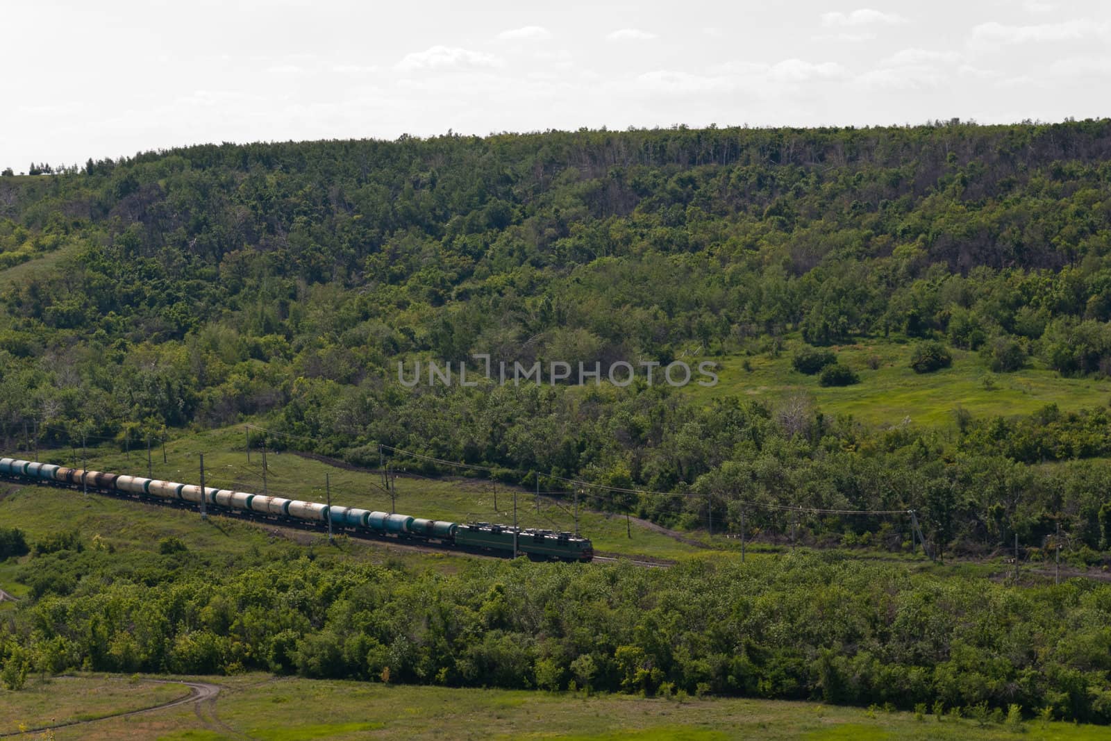 Freight Train Going by Railway Against Summer Landscape