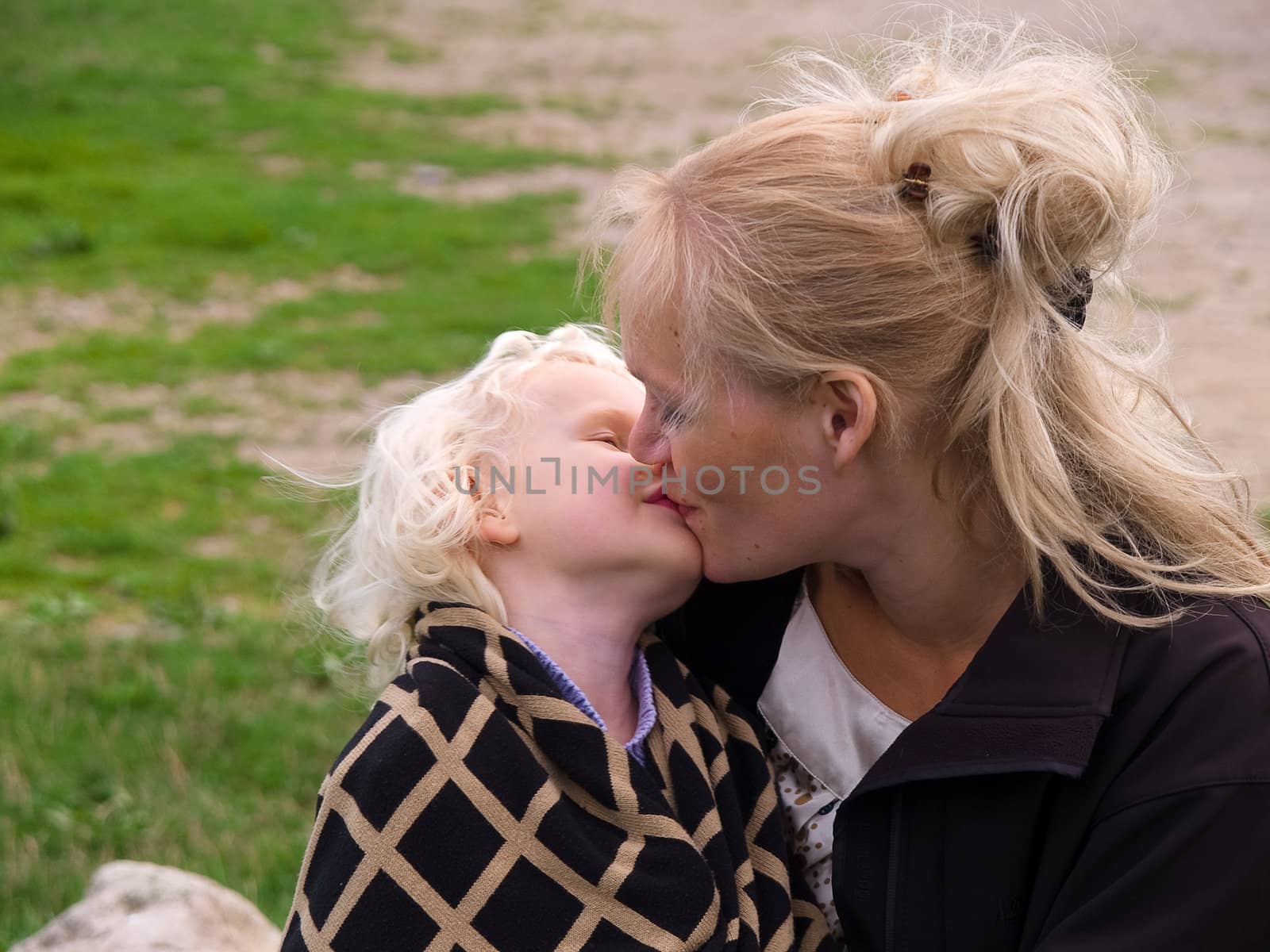 Close Up Of Affectionate Mother And Daughter kissing outdoors in nature