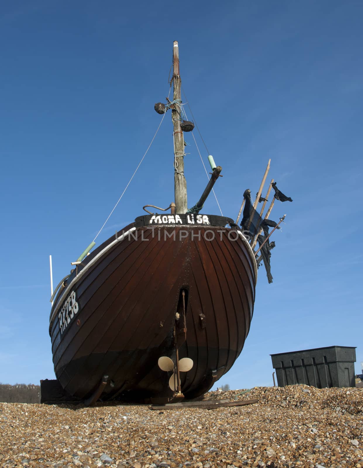Brown fishing boat on the beach waiting to be towed to the sea