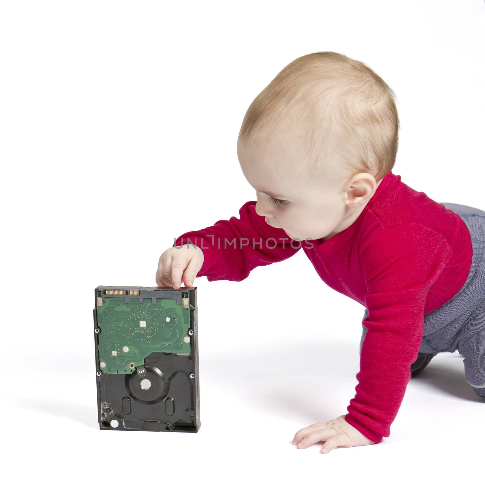 young child in white background with hard drive. red shirt and blue trousers