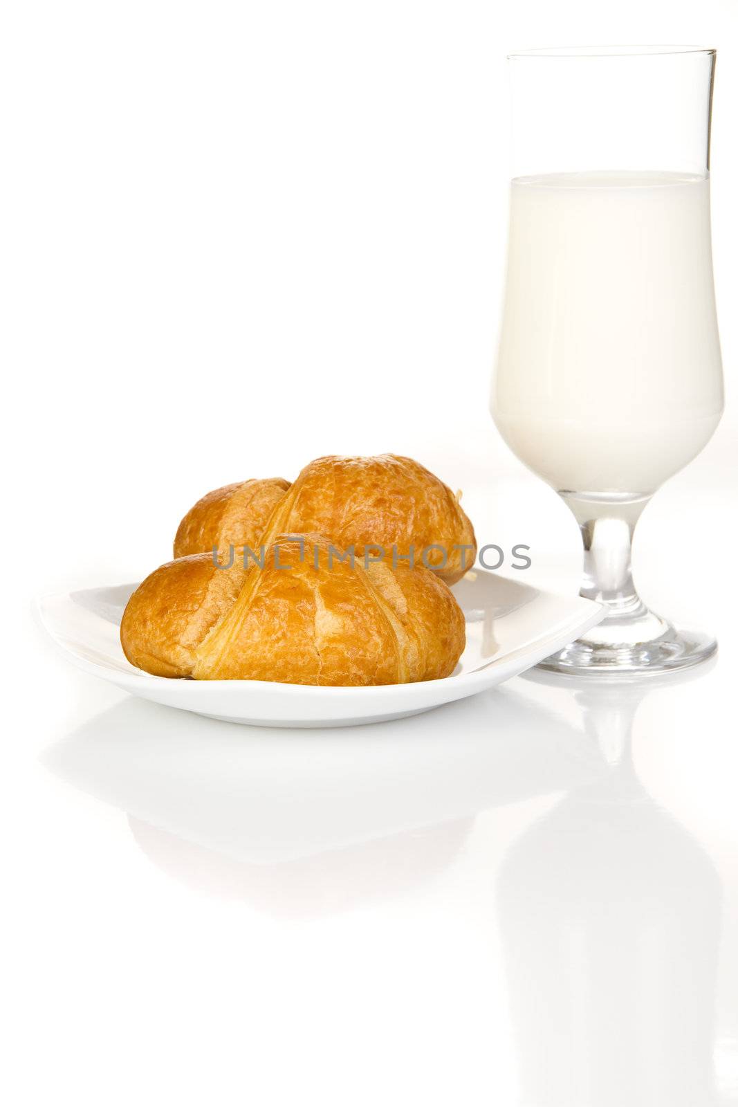 French croissants and milk over white background