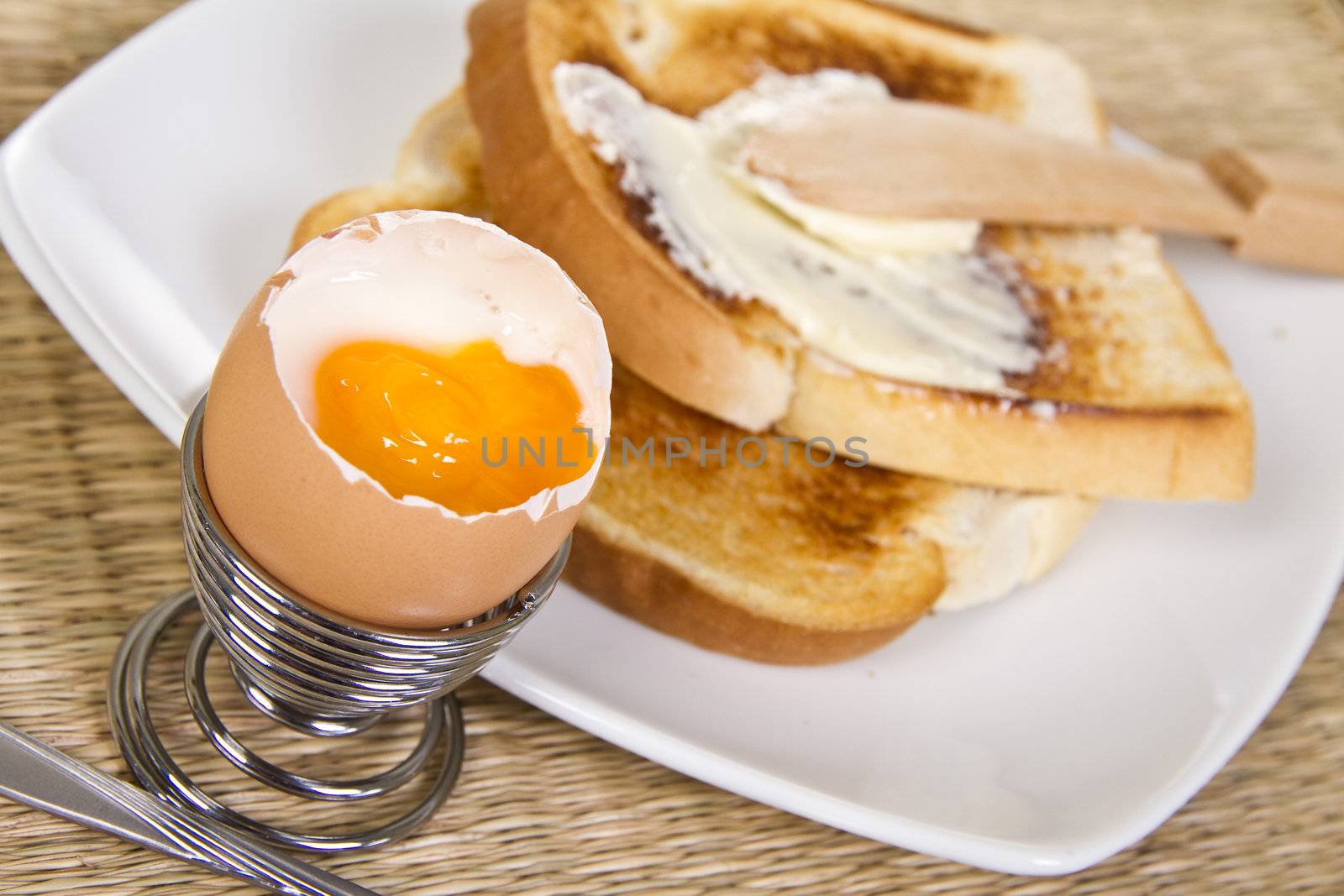 Soft boiled egg with crispy toasts on the plate