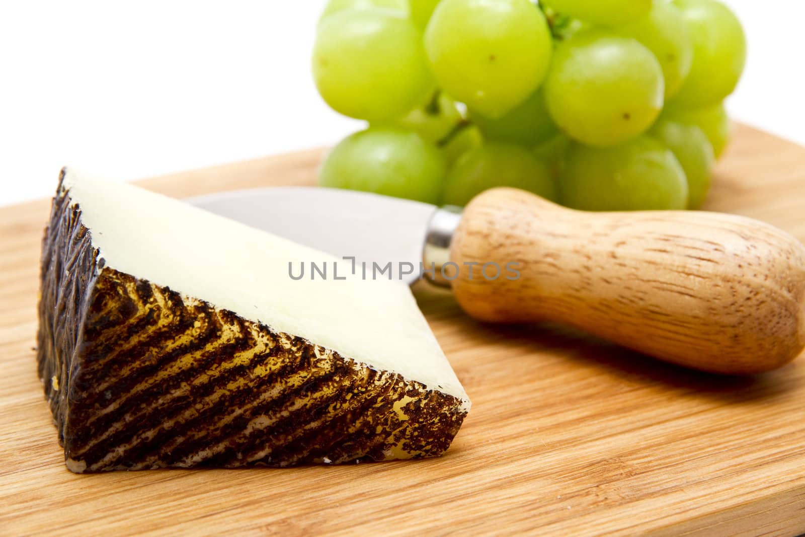 Manchego cheese ang grapes on chopping board by caldix