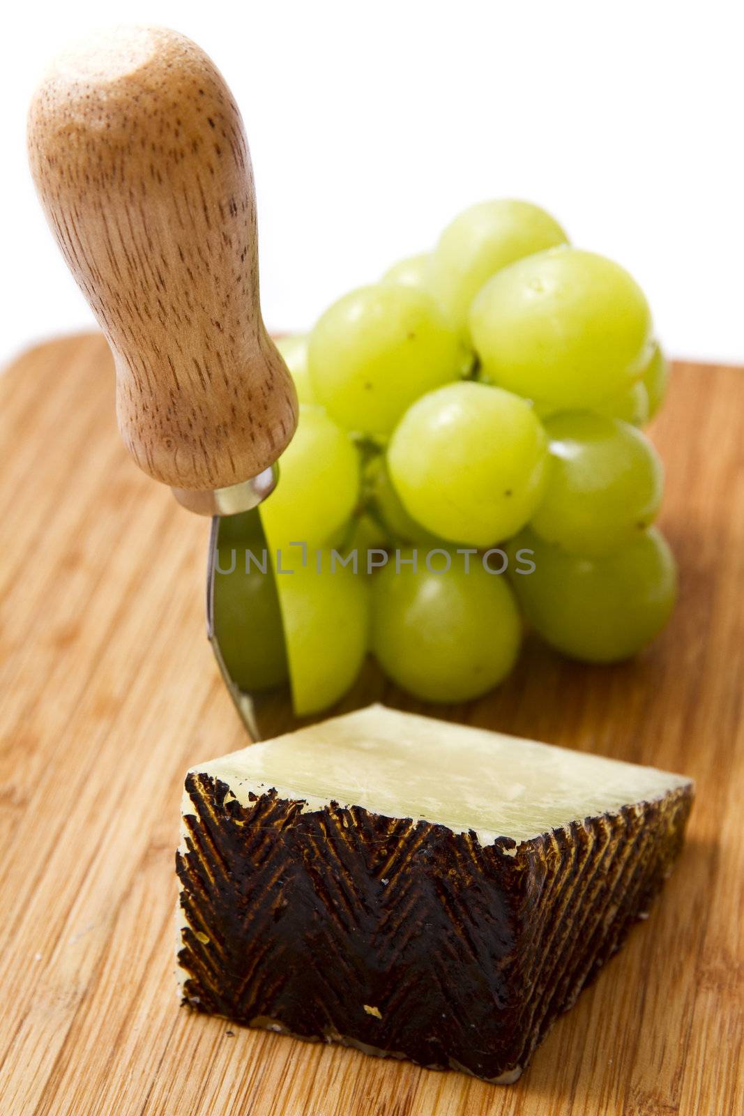 Manchego cheese ang grapes on chopping board by caldix