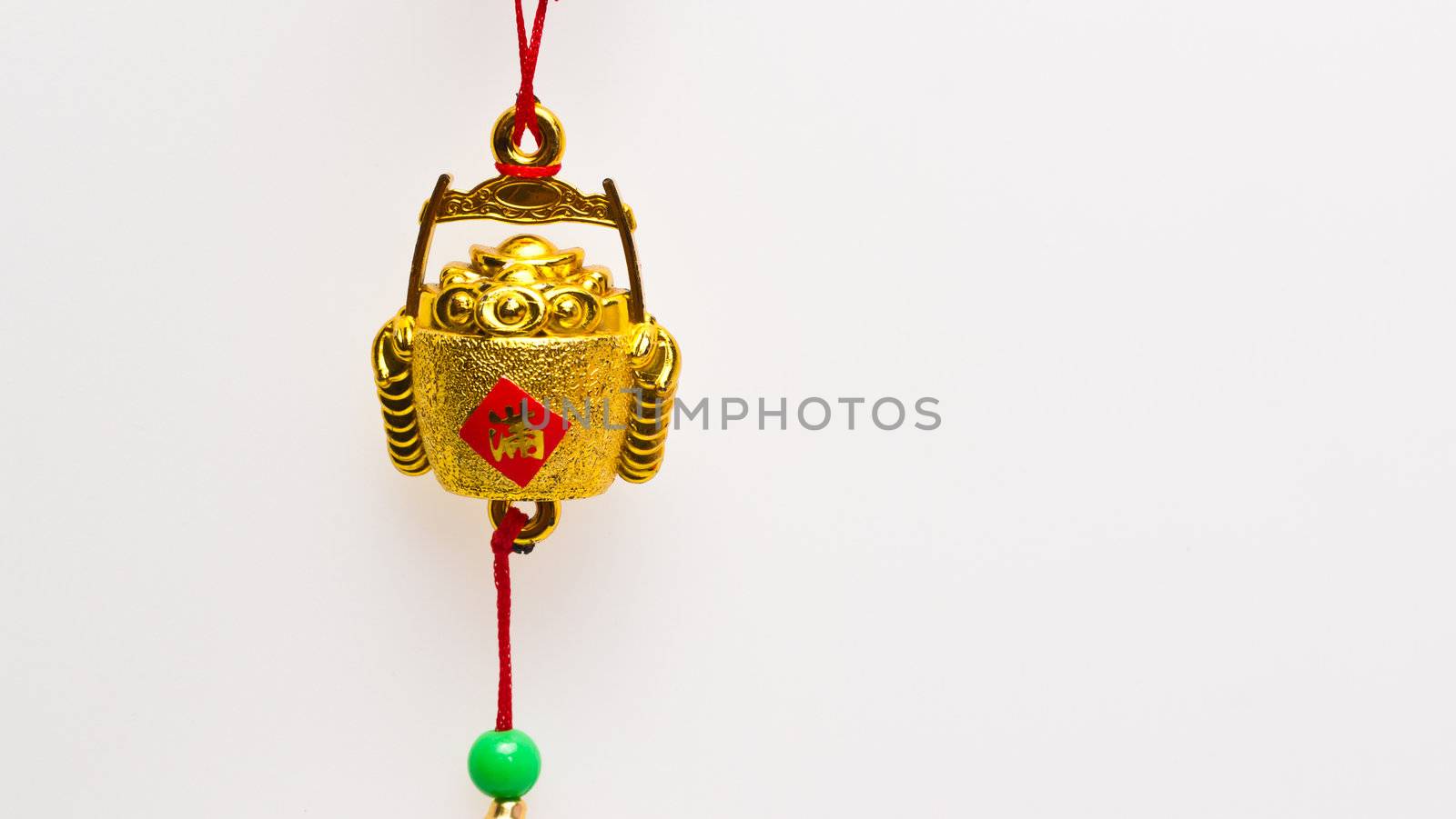 Hanging wealth pot pendant for Chinese New Year celebration against white surface