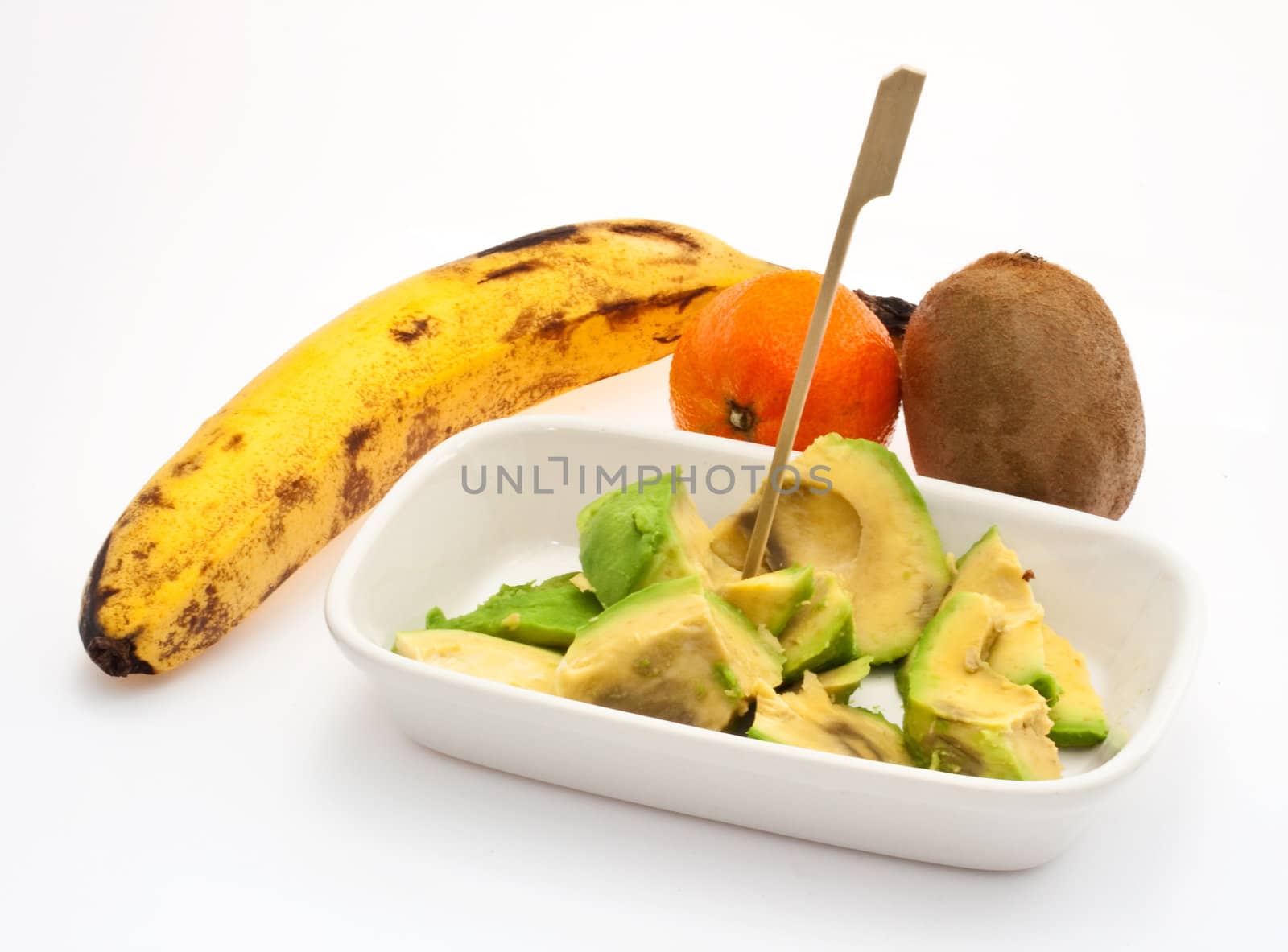 Avocado, babana, kiwi and tangerine on white