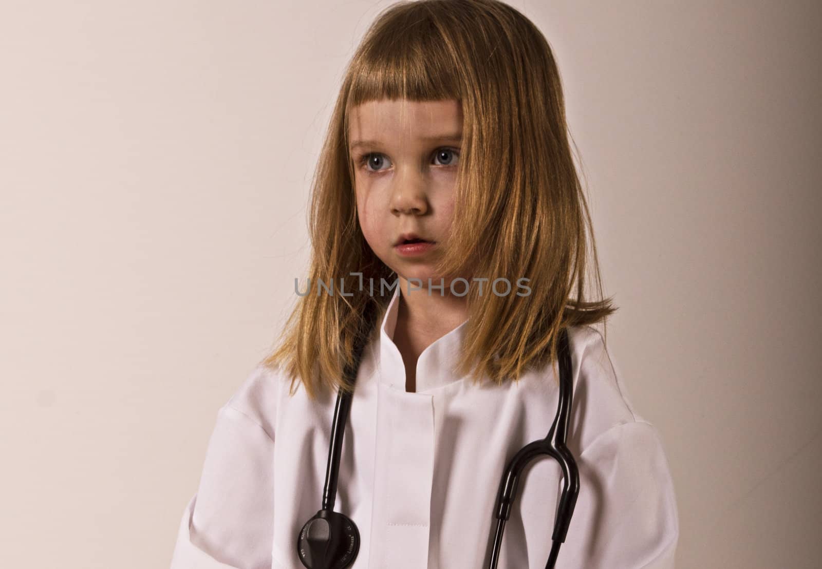 little girl is a doctor in gown and stethoscope