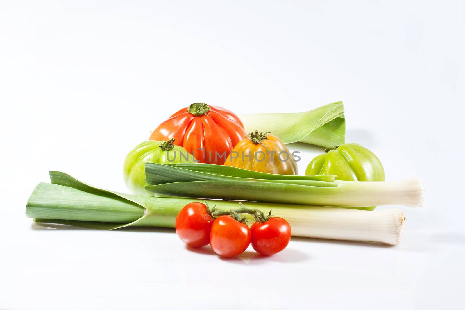 Leeks and tomatoes isolated on a white background