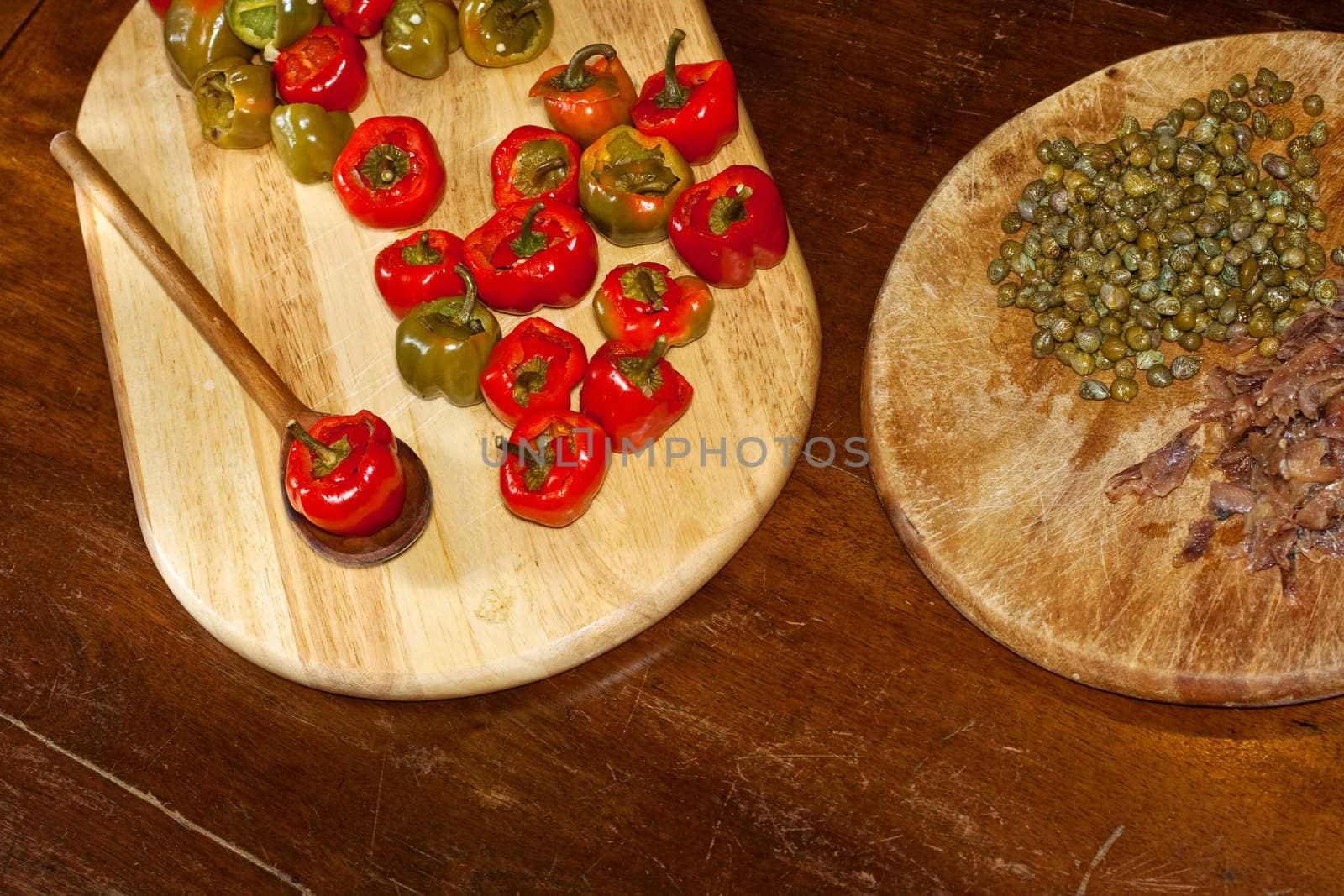 Red hot chili peppers on cutting board, capers and anchovies