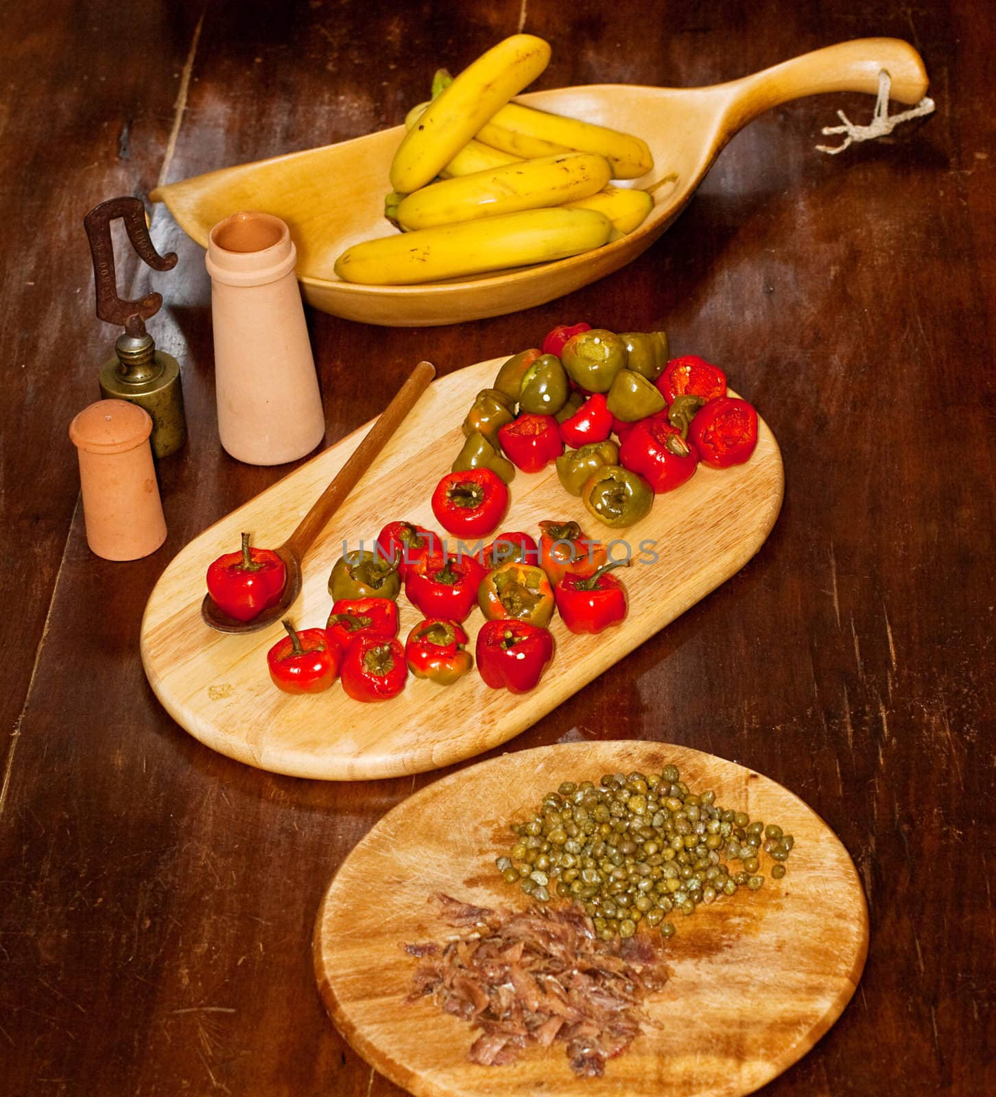 Red hot chili peppers on cutting board, bananas, capers and anchovies