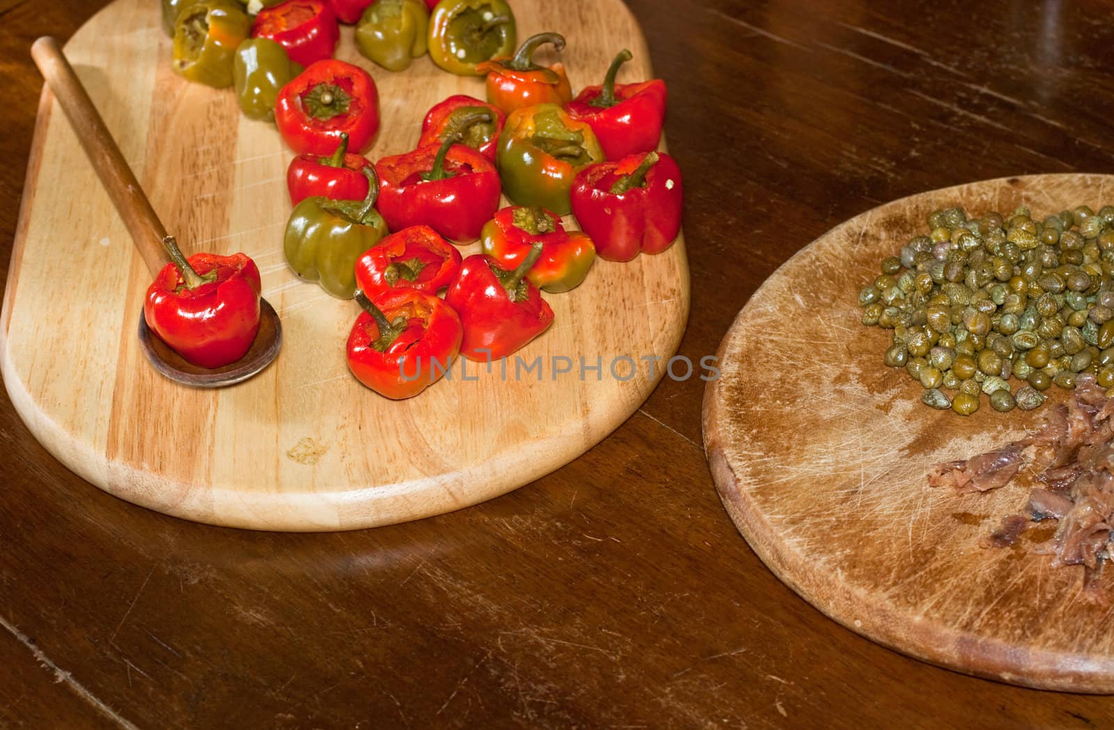 Red hot chili peppers on cutting board, capers and anchovies