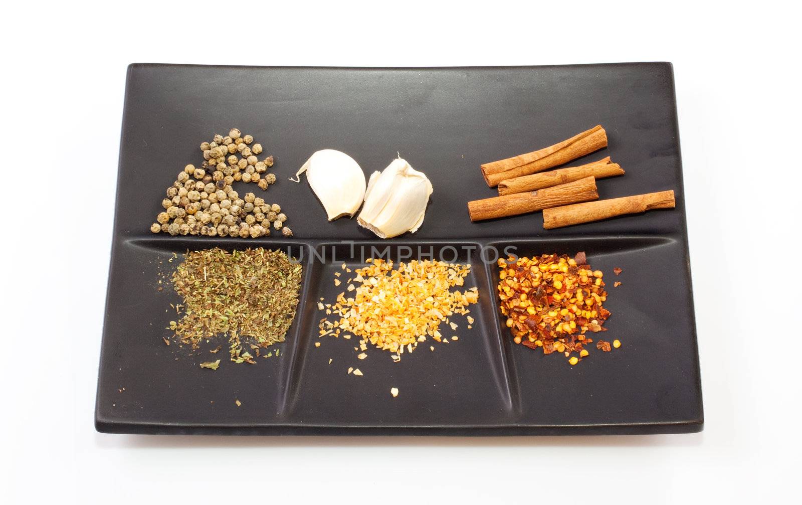 Different Spices on a black saucer