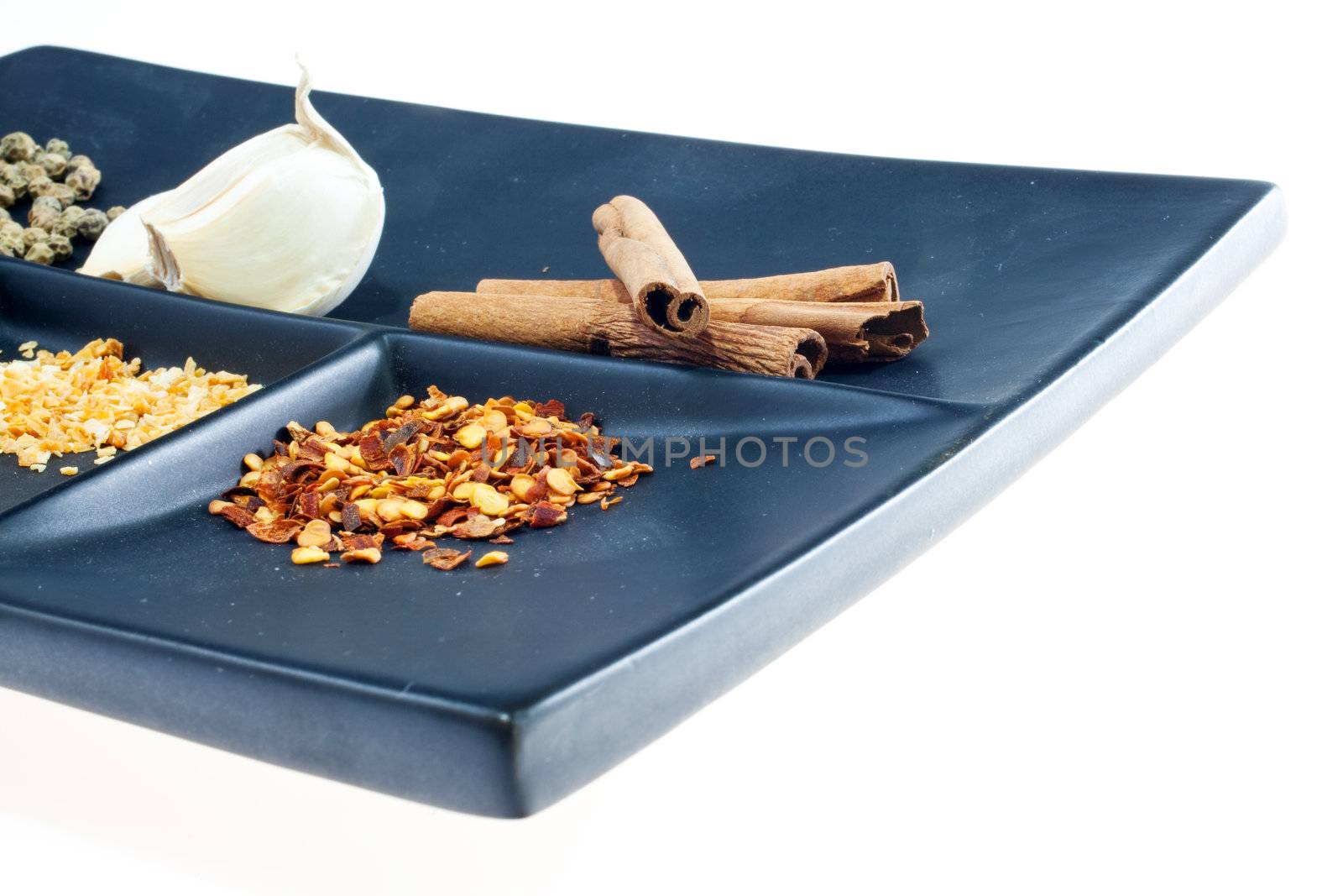 Different Spices on a black saucer