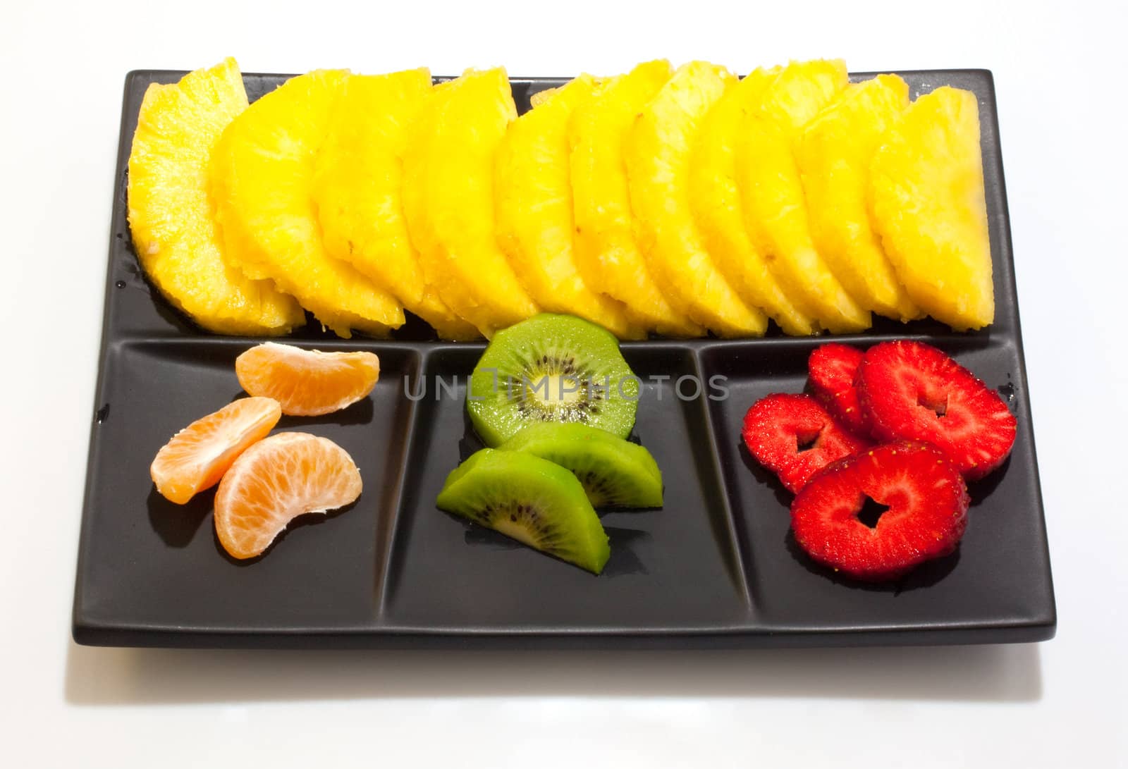 Sliced fruits on black saucer