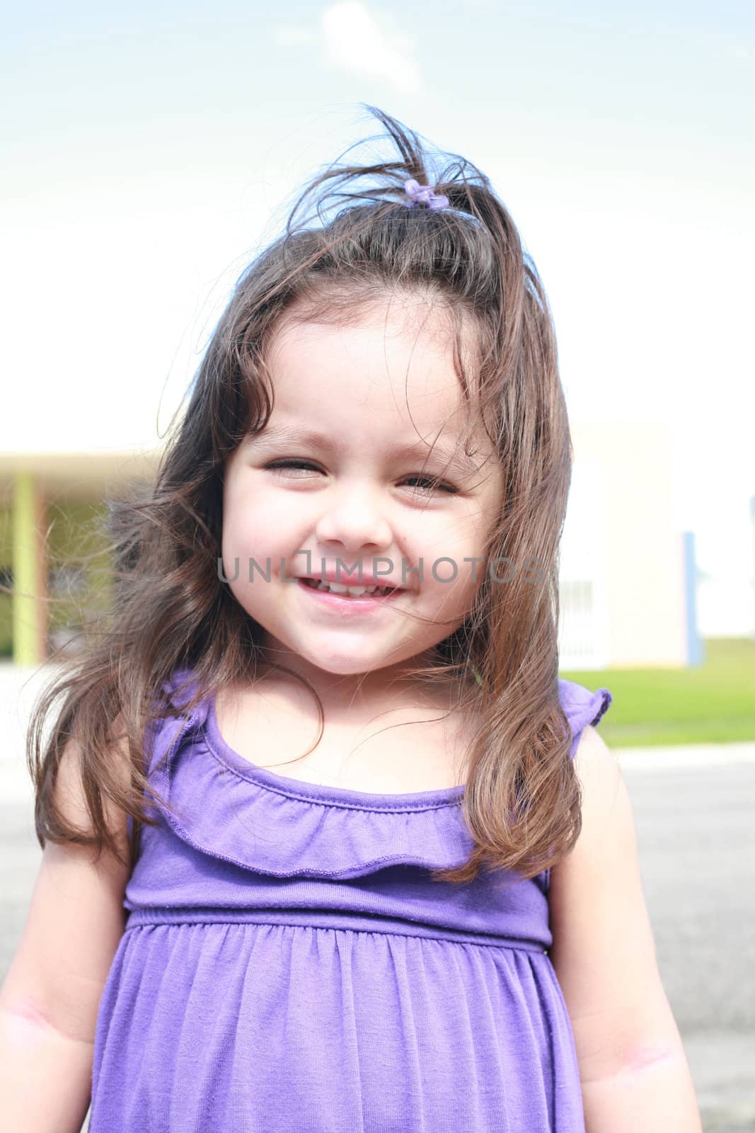 cute little girl smiling in a park close-up