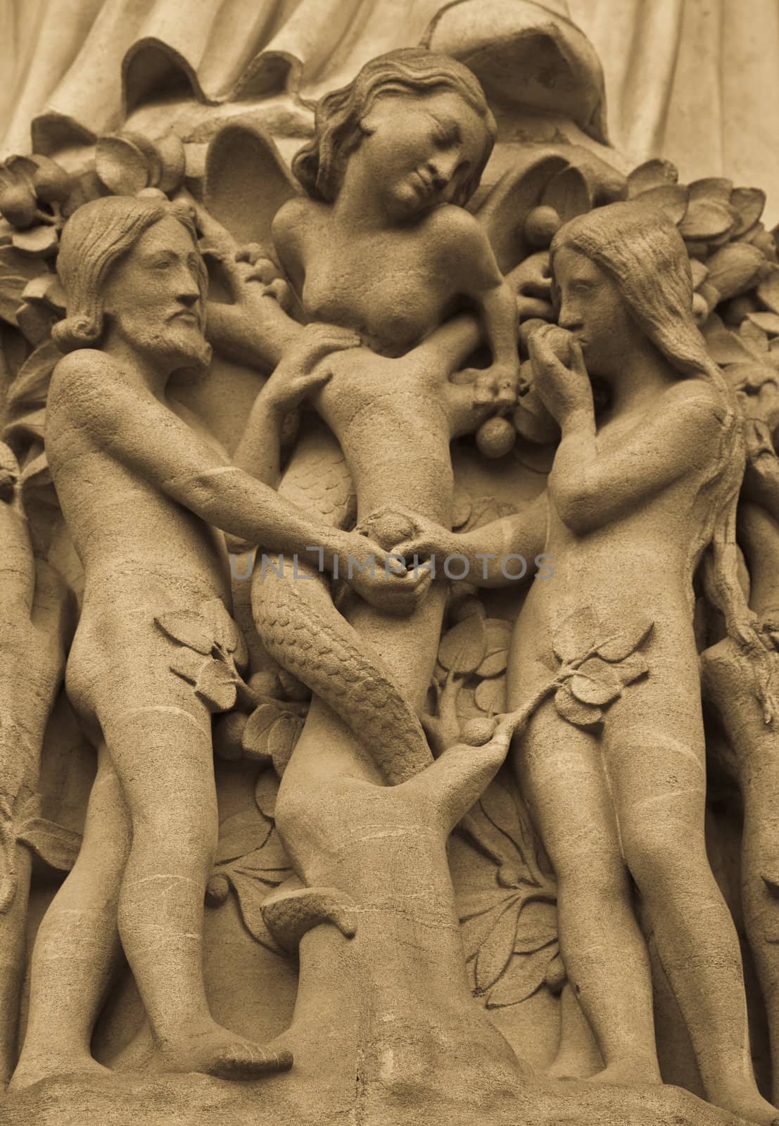 Detail on Notre Dame de Paris Cathedral fachade: Adame, Eve and the forbidden apple