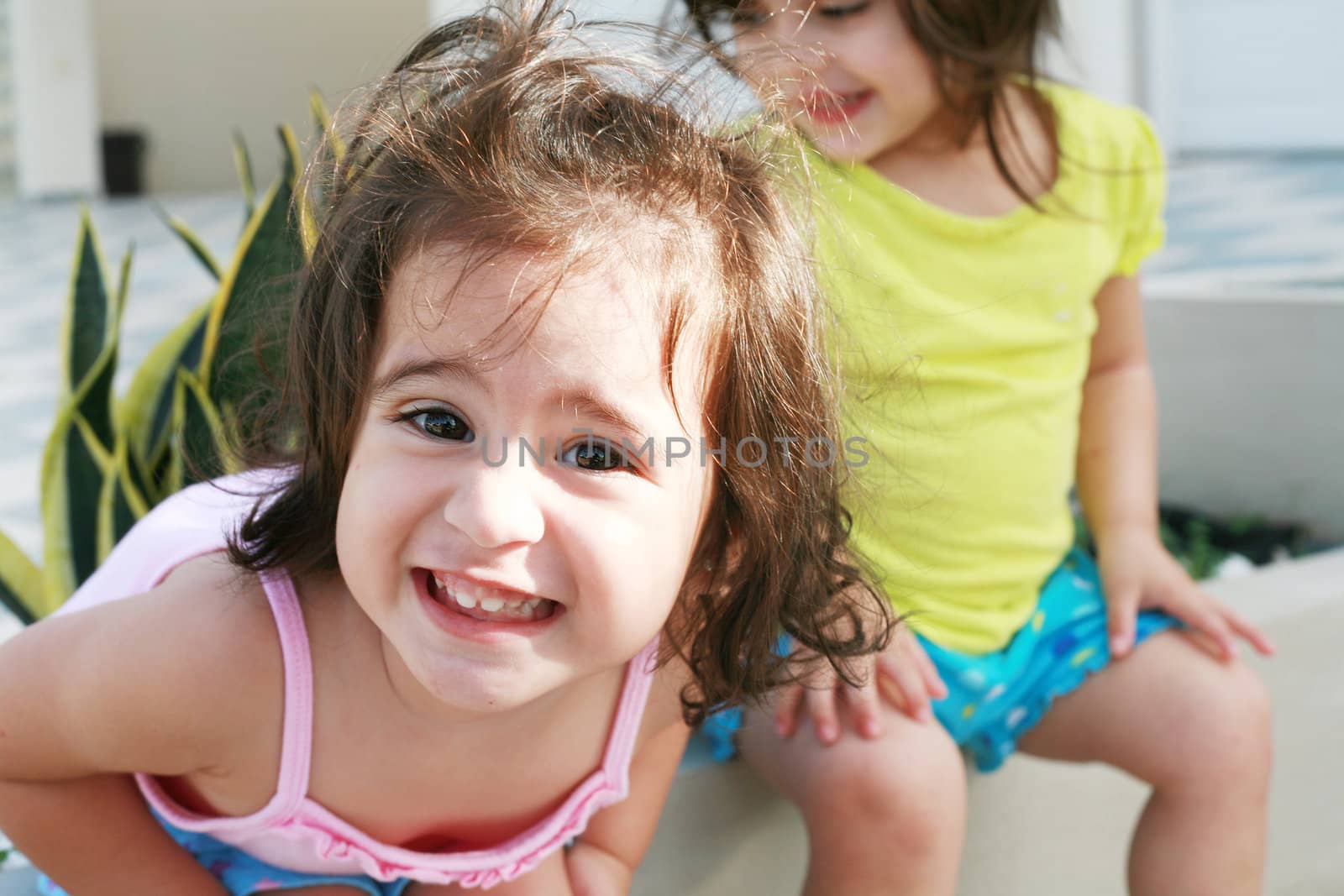 Sweet little girls in front of her little house for playtime (focus on the front girl)