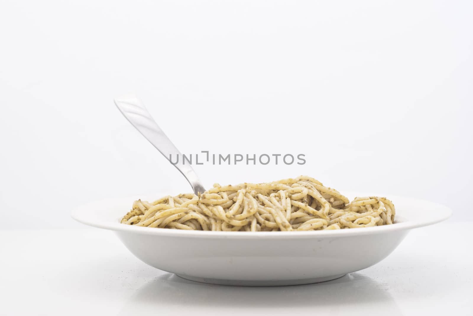 Spaghetti with pesto isolated on white background