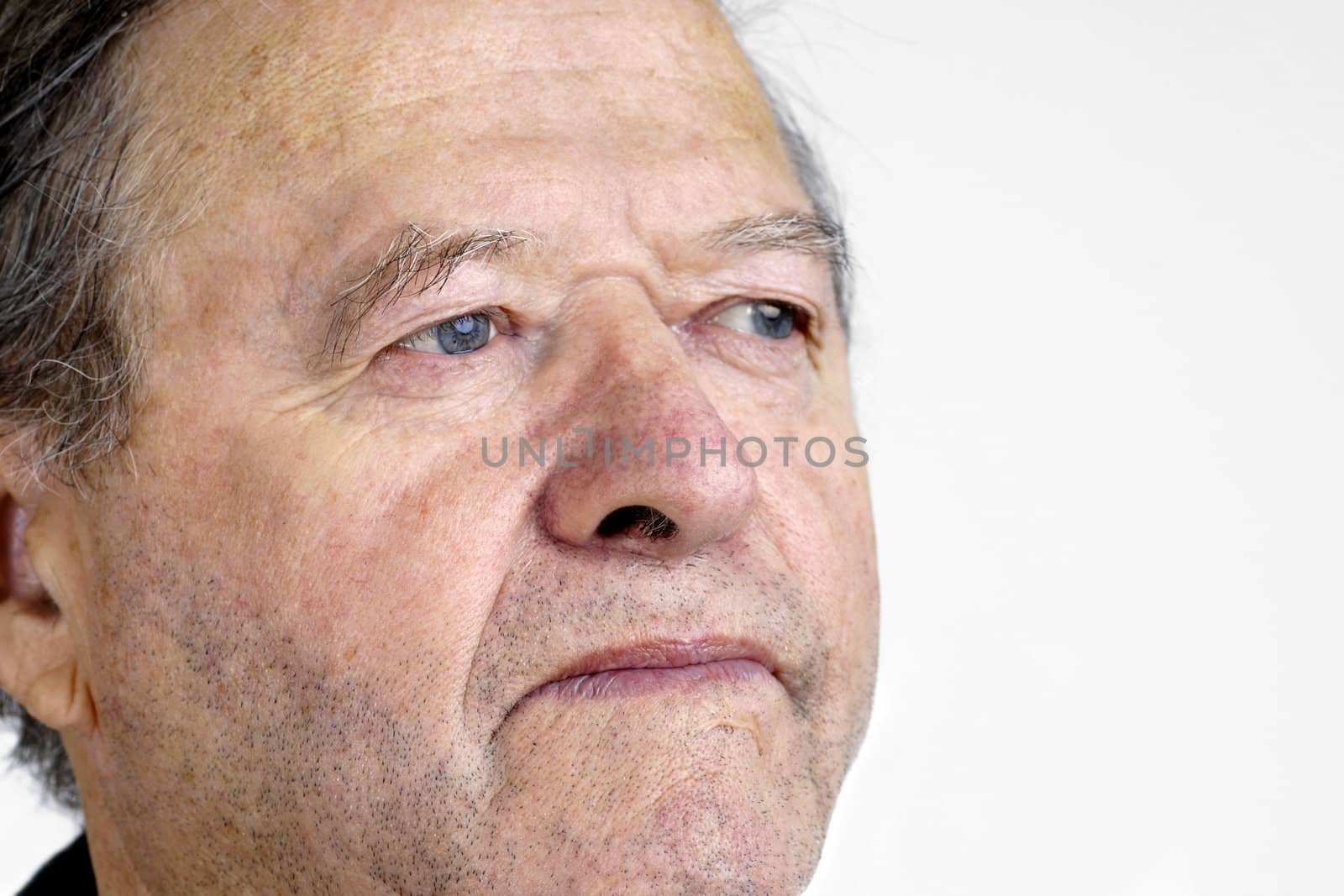 Portrait of a senior man with blue eyes looking away with hint of a smile, great facial details, over white.