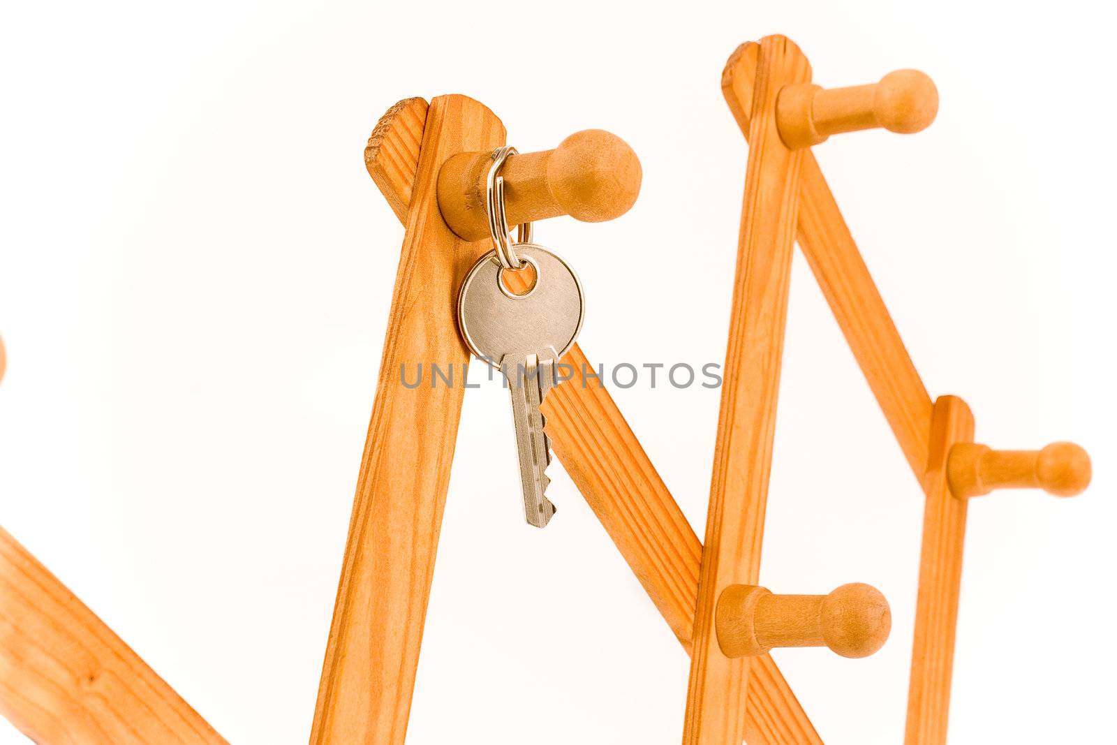 House key hanging on wooden hook isolated on white