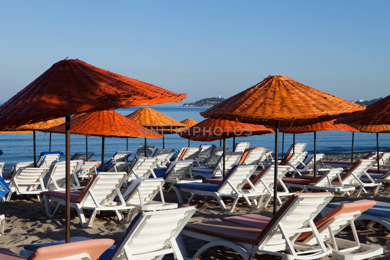 Beach loungers and umbrellas on the sea.